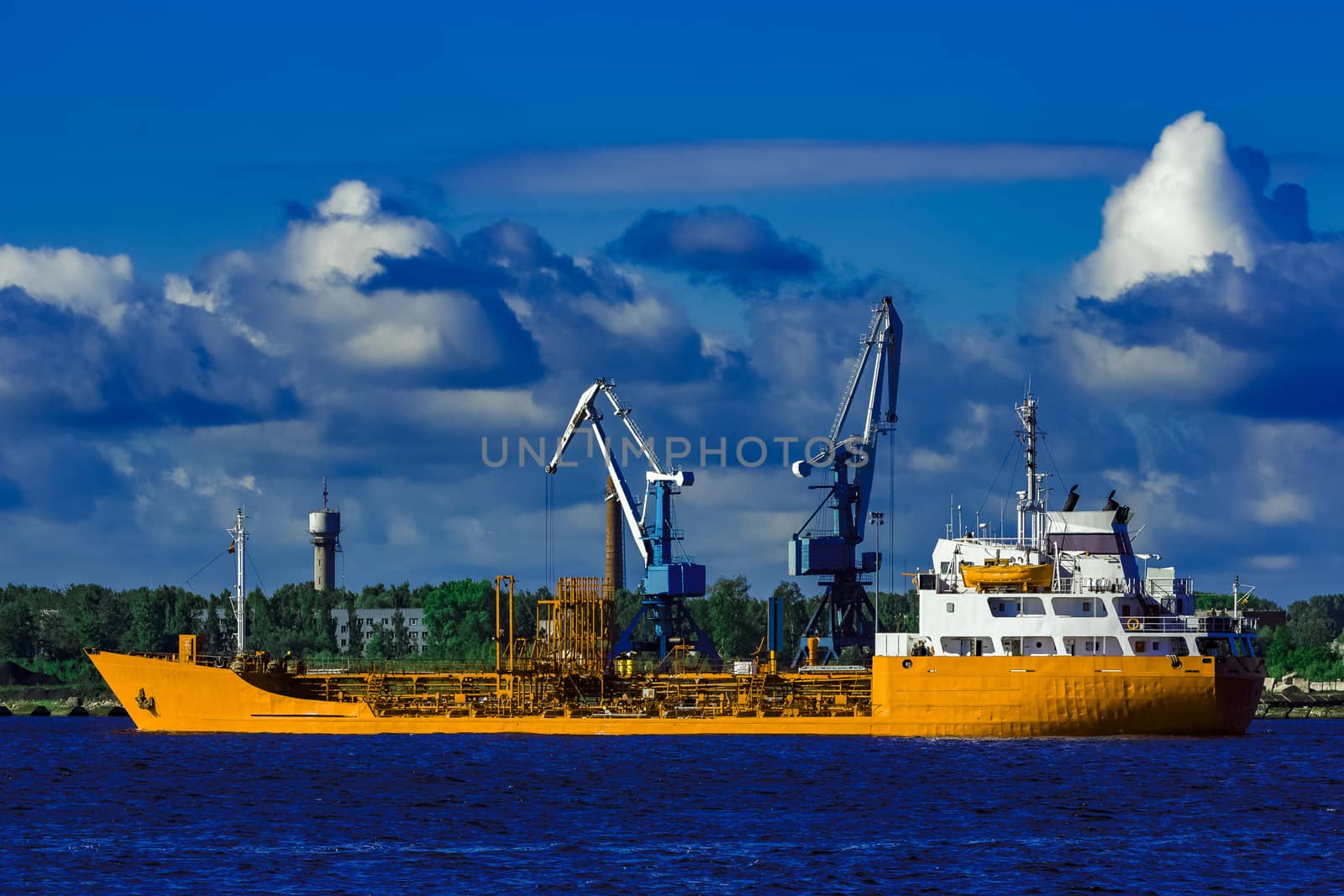 Yellow cargo tanker ship moving at the clear summer day