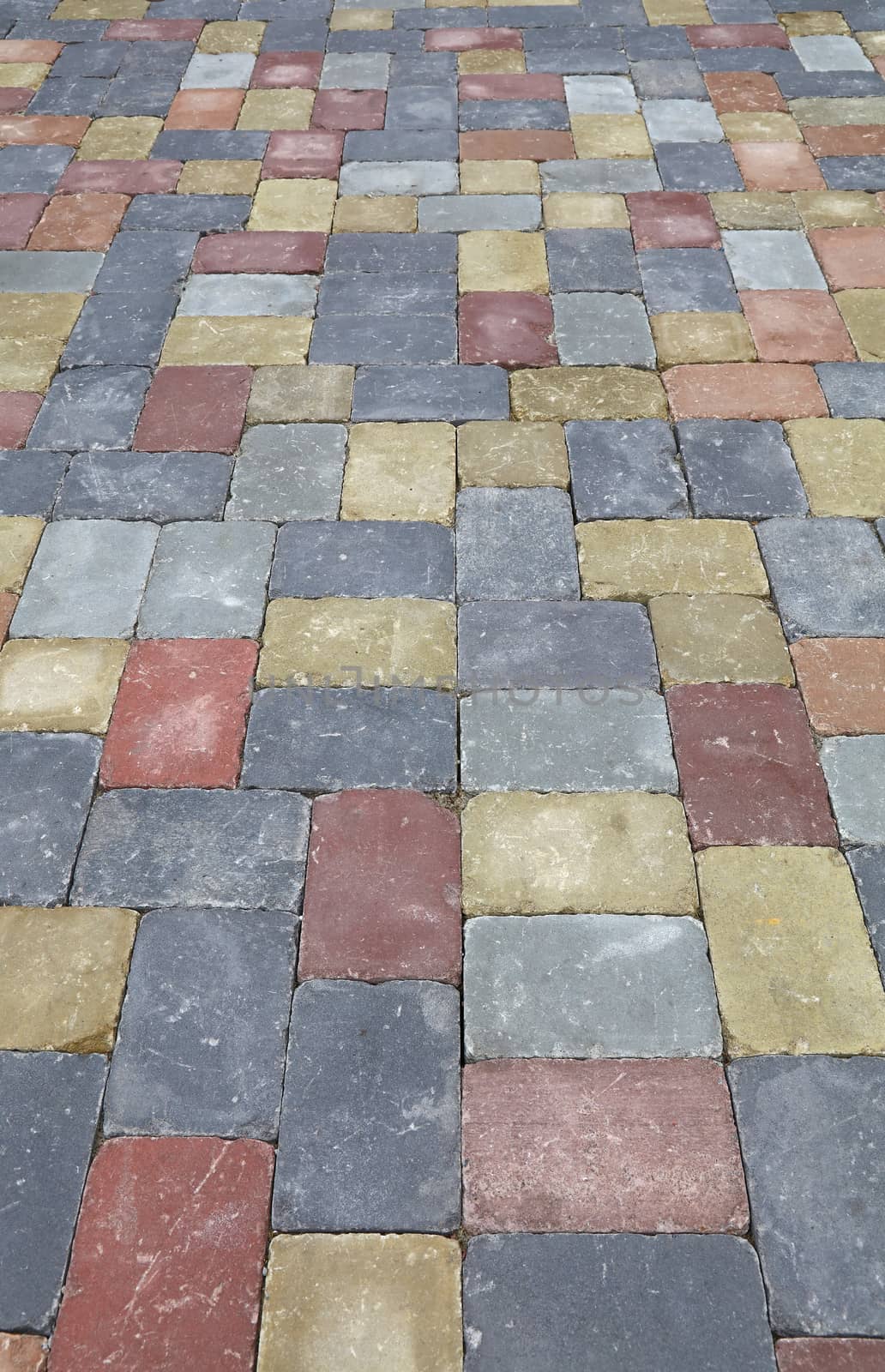 Background of street road colorful stone paving of multicolor bricks, close up, high angle view