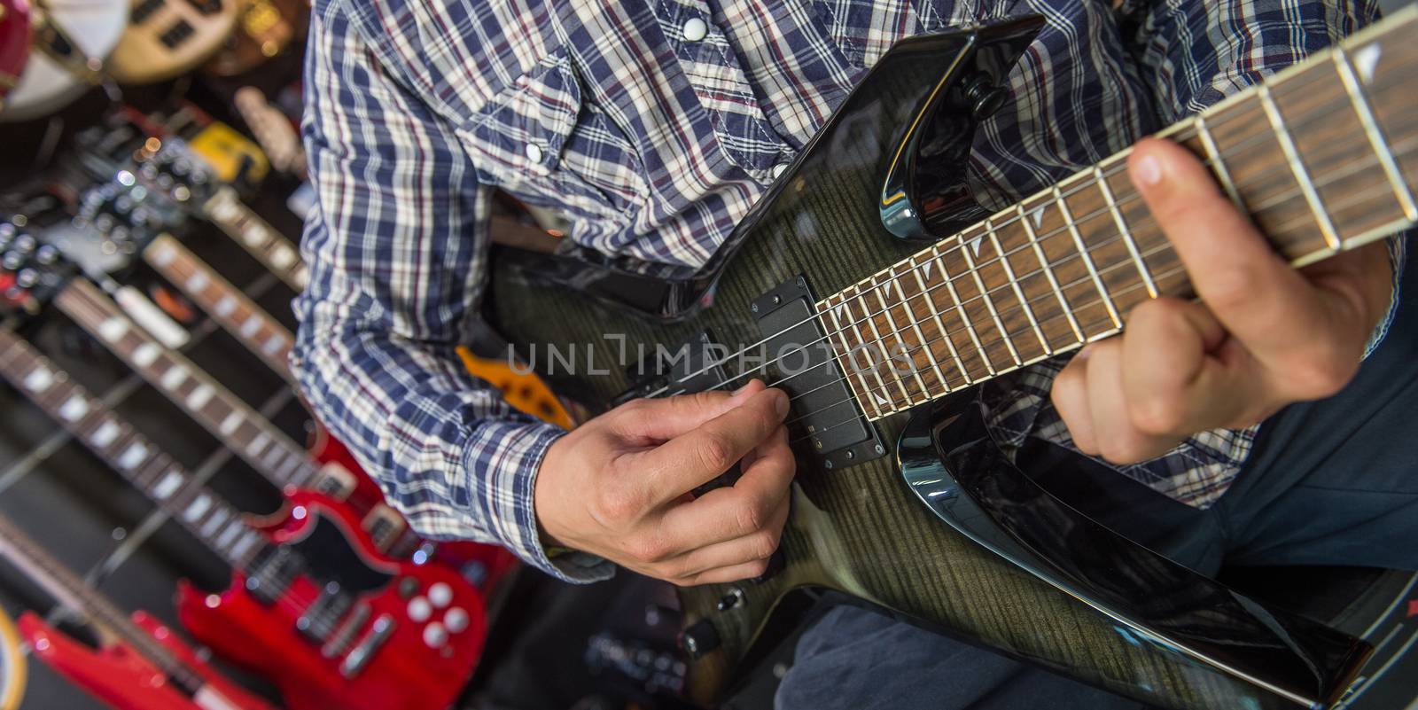 Young man playing the guitar in a shop, France