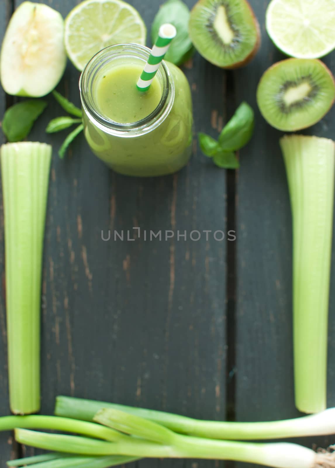 Blended smoothie with fresh ingredients on a wooden table with space for text 