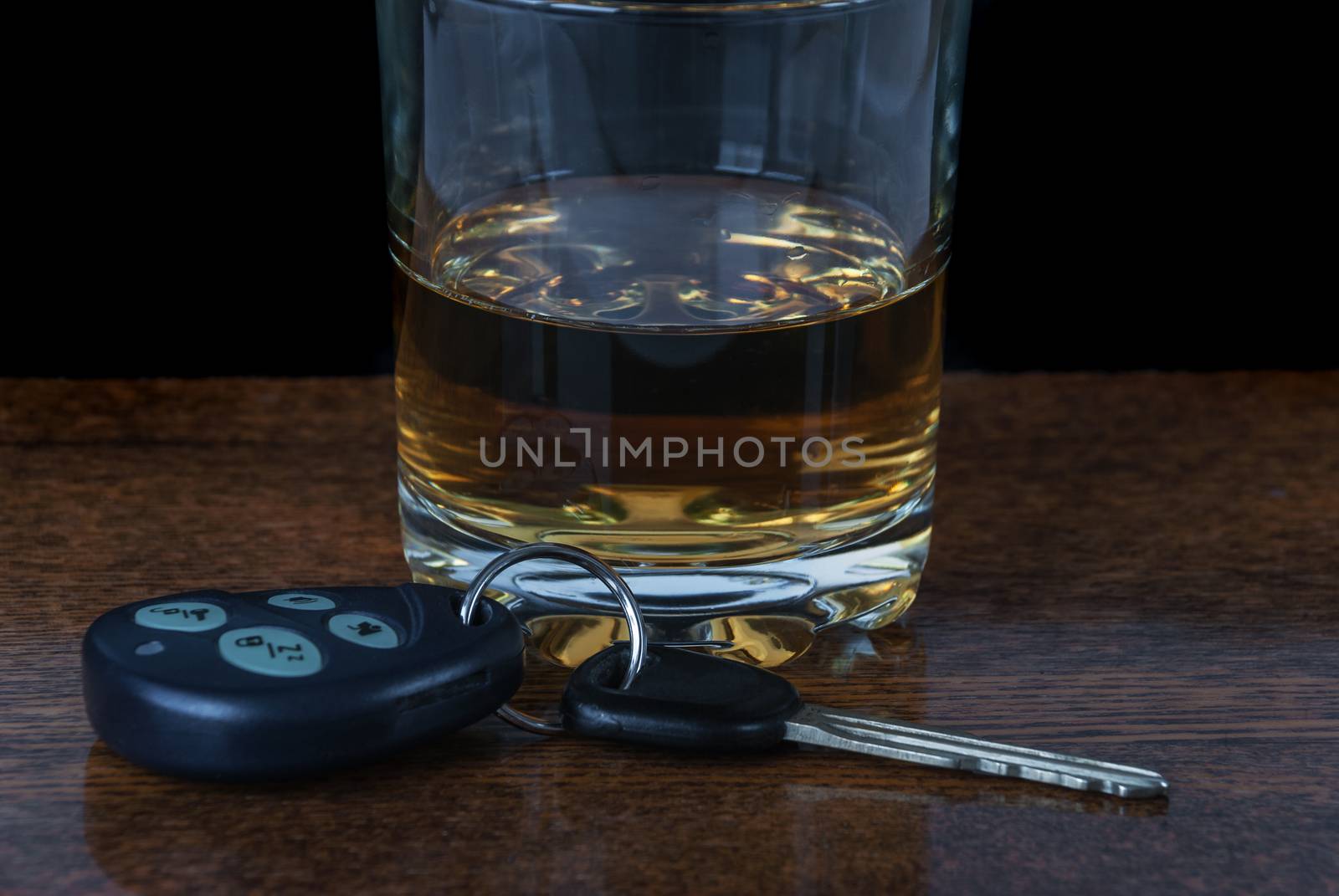 Concept driving and drinking: glass of alcohol and car keys on the bar