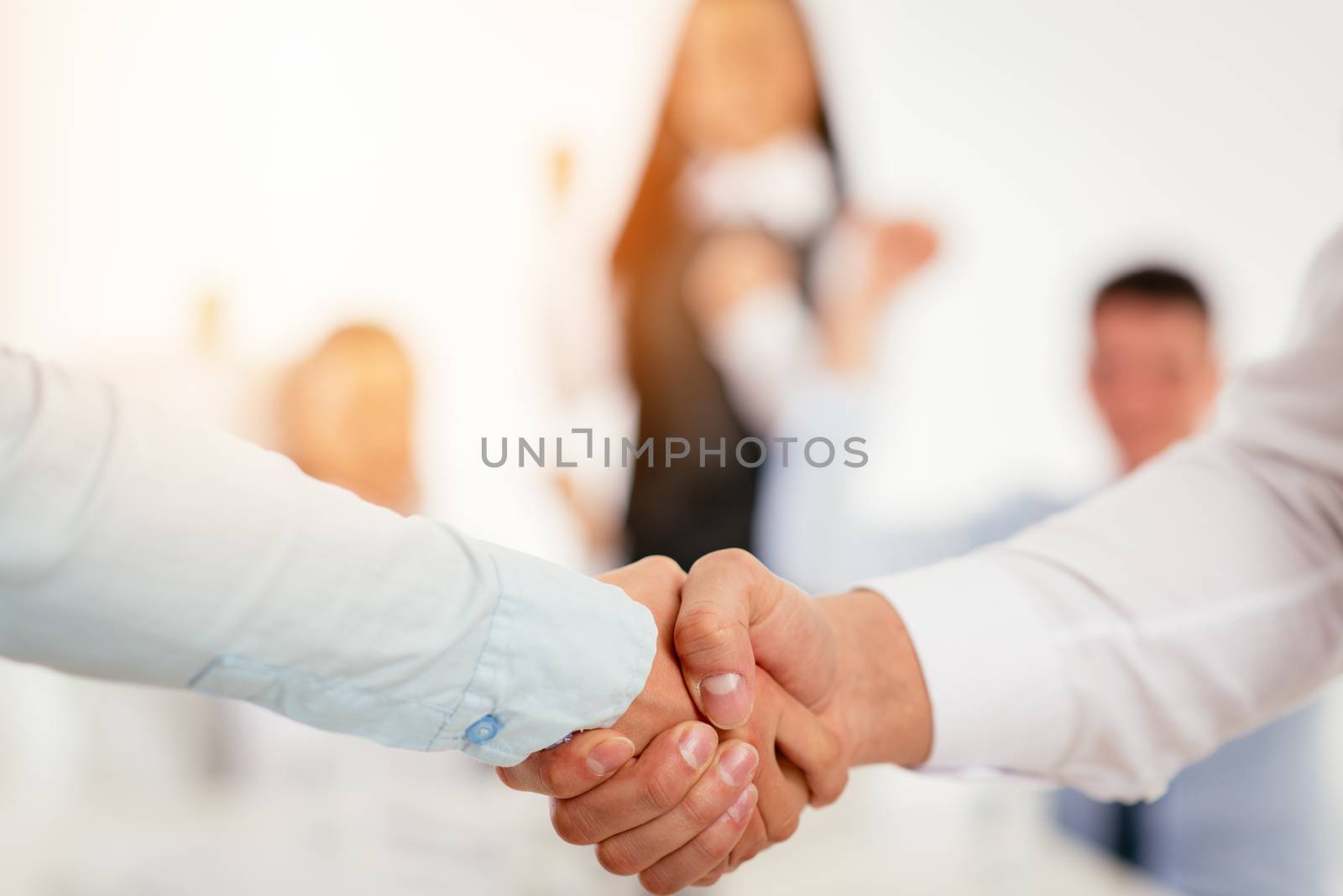 Close-up of a two business people shaking hands over a good agreement.