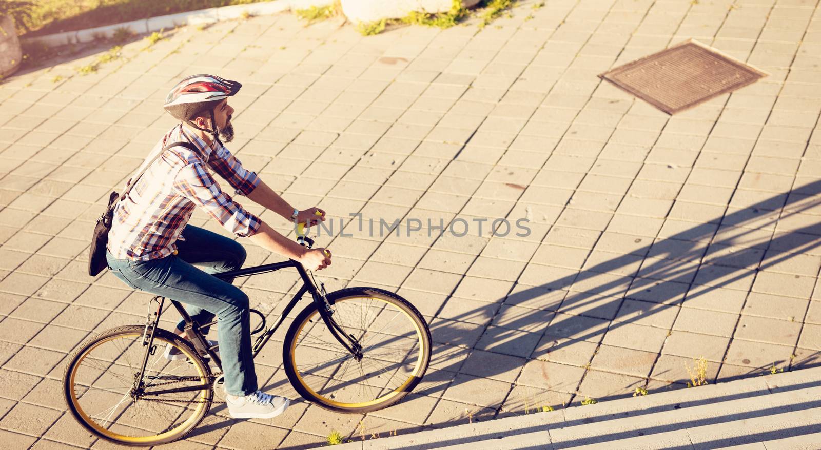 Casual businessman with a helmet going to work by bicycle.