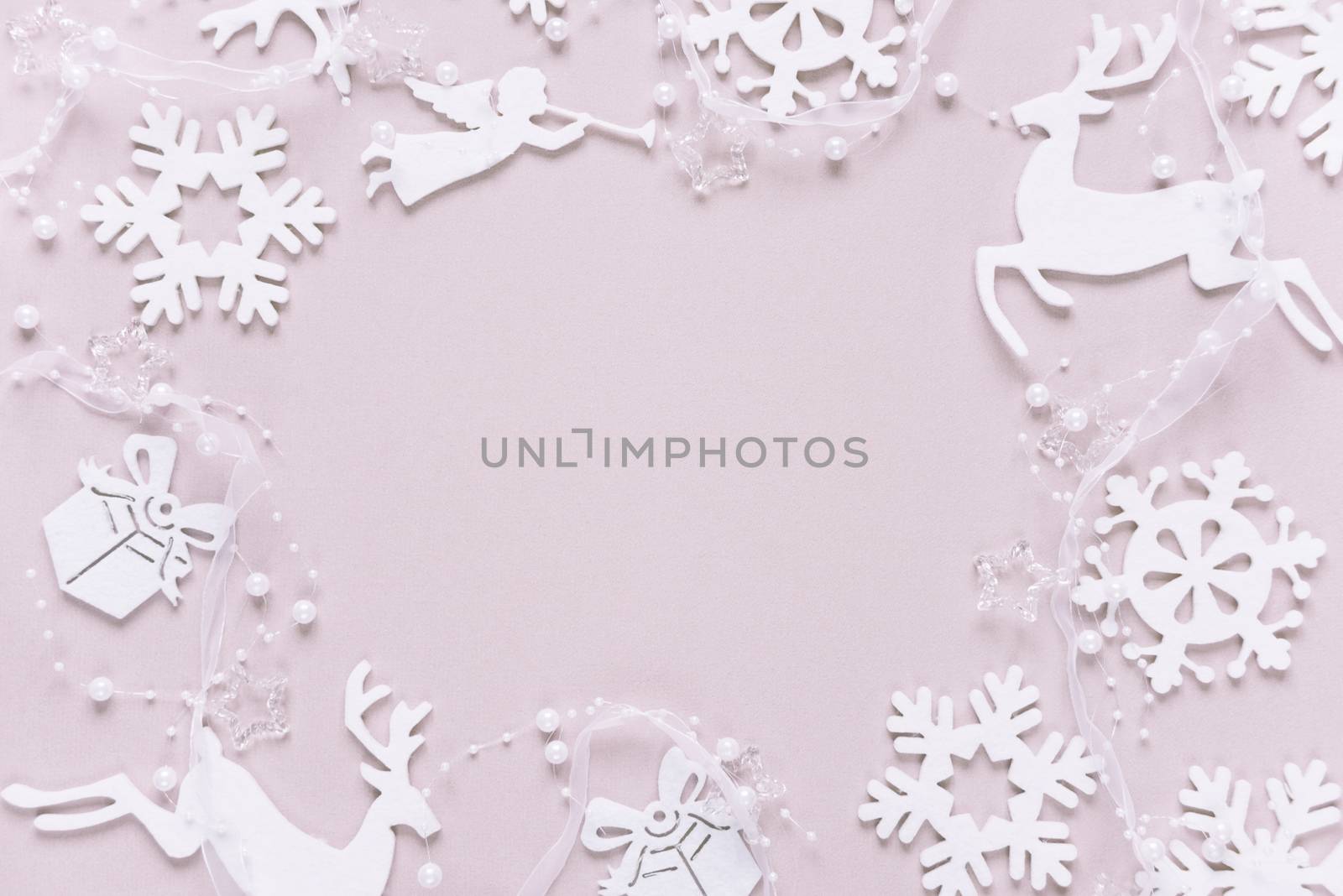 Christmas frame composed of white christmas decoration: snowflakes, deers, flying angel and gift boxes on pink background. Flat lay composition for websites, social media, business owners, magazines,  bloggers, artists etc.