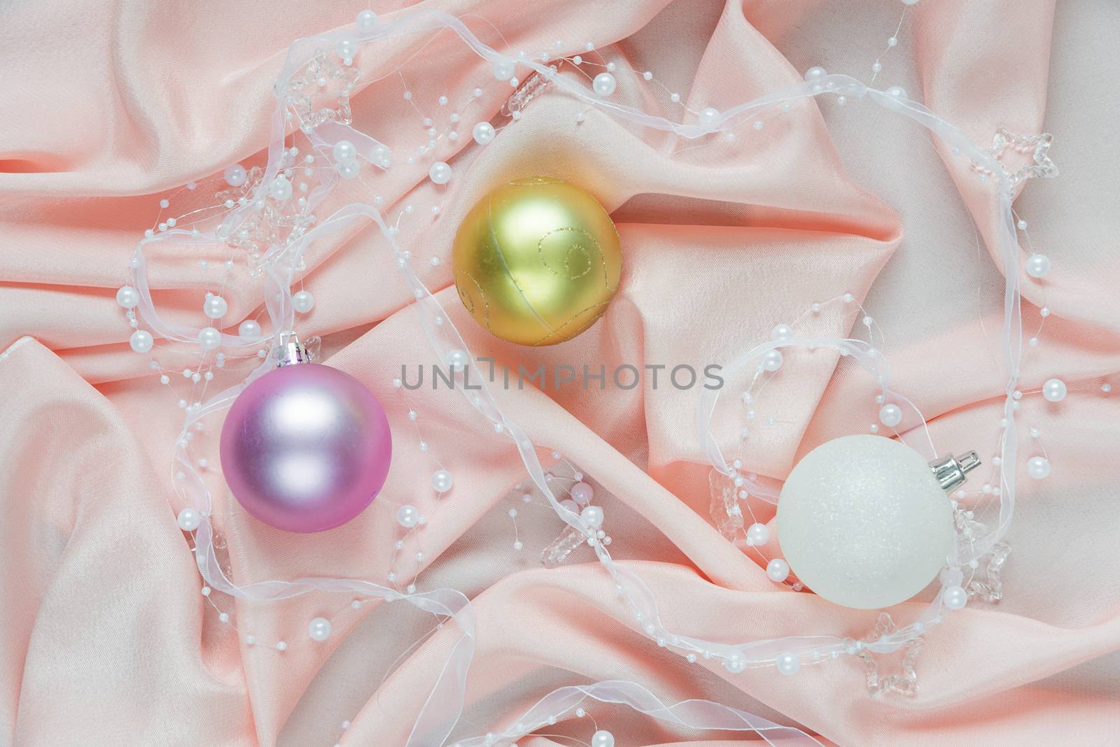 Beautiful Christmas composition with Christmas balls on a pink folded silk. Flat lay composition for greeting cards, websites, social media, magazines, bloggers, artists etc. Christmas wallpaper