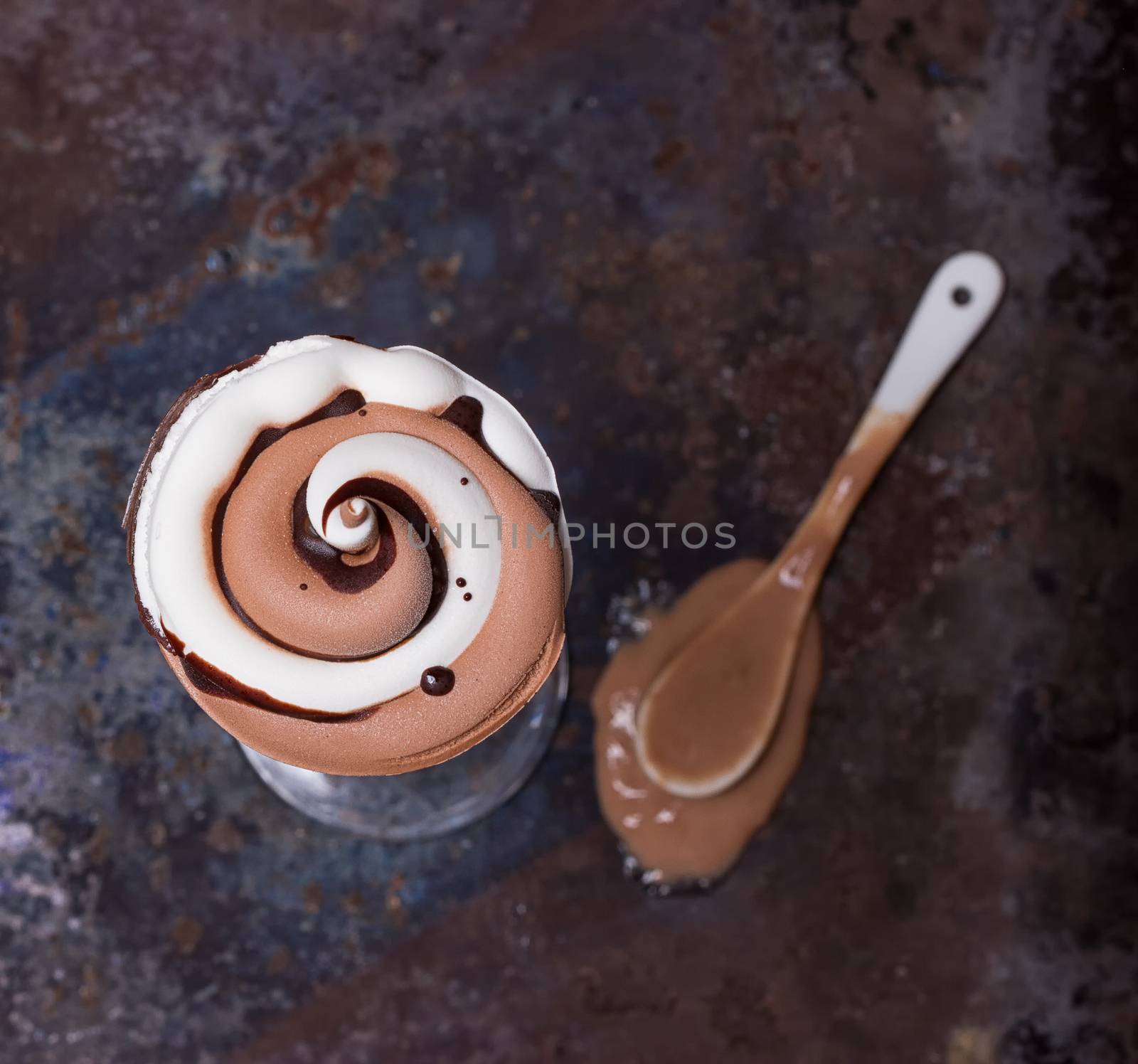 Wafer horn with chocolate ice cream and melted ice cream on grunge background