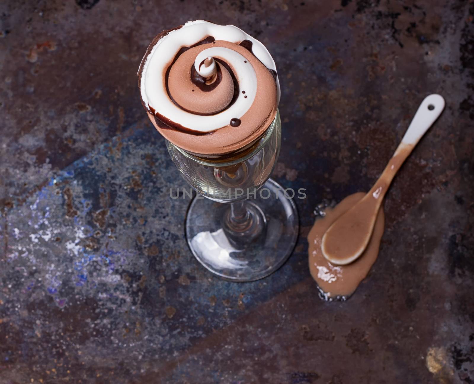 Wafer horn with chocolate ice cream and melted ice cream on grunge background