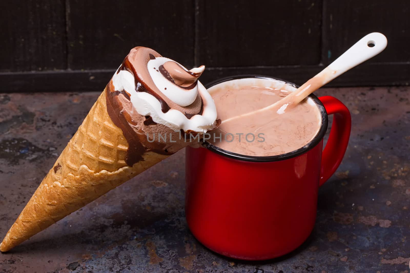 Wafer horn with chocolate ice cream and melted ice cream on grunge background