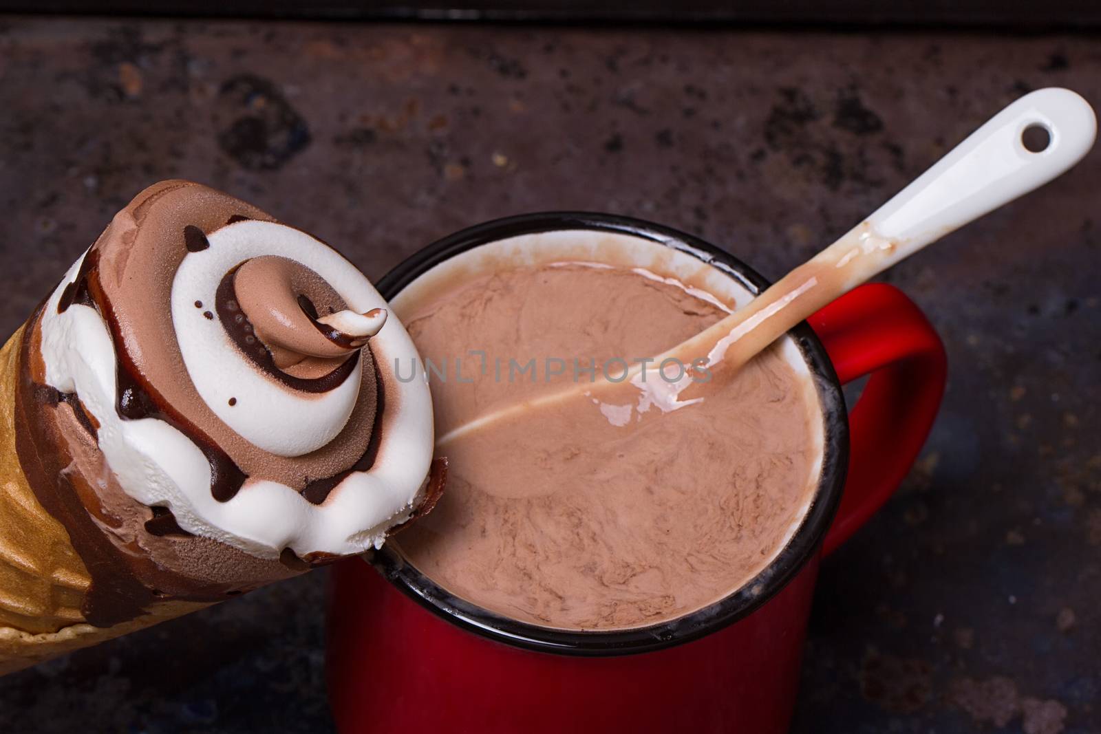 Wafer horn with chocolate ice cream and melted ice cream on grunge background