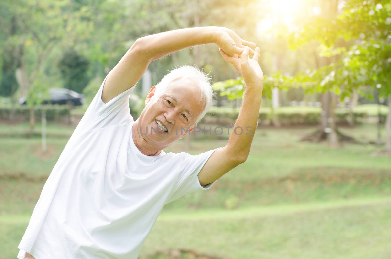 Portrait of healthy and fitness gray hair Asian old man stretching at outdoor park in morning.