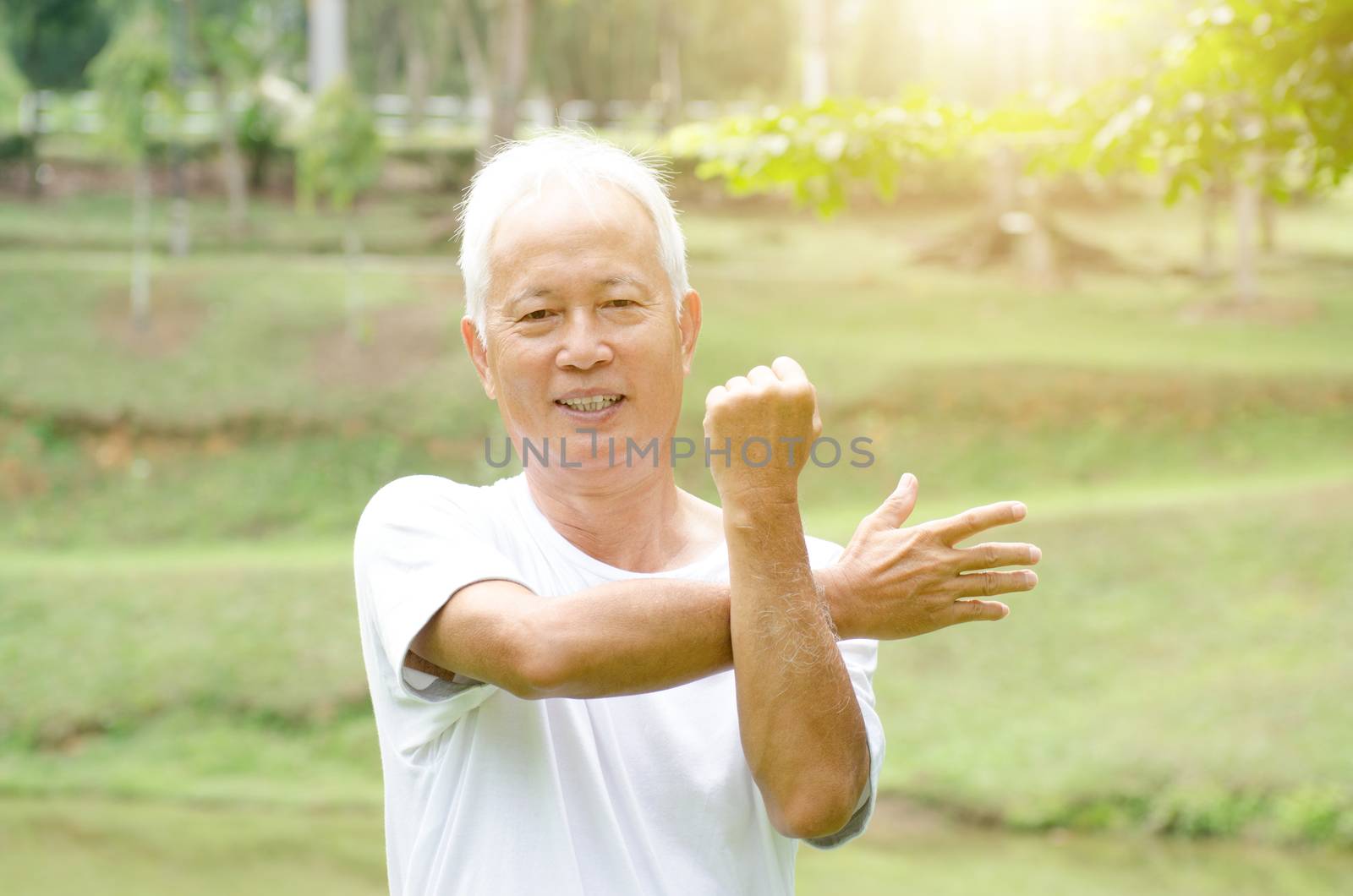 Portrait of healthy and sporty gray hair Asian old man stretching at outdoor park in morning.