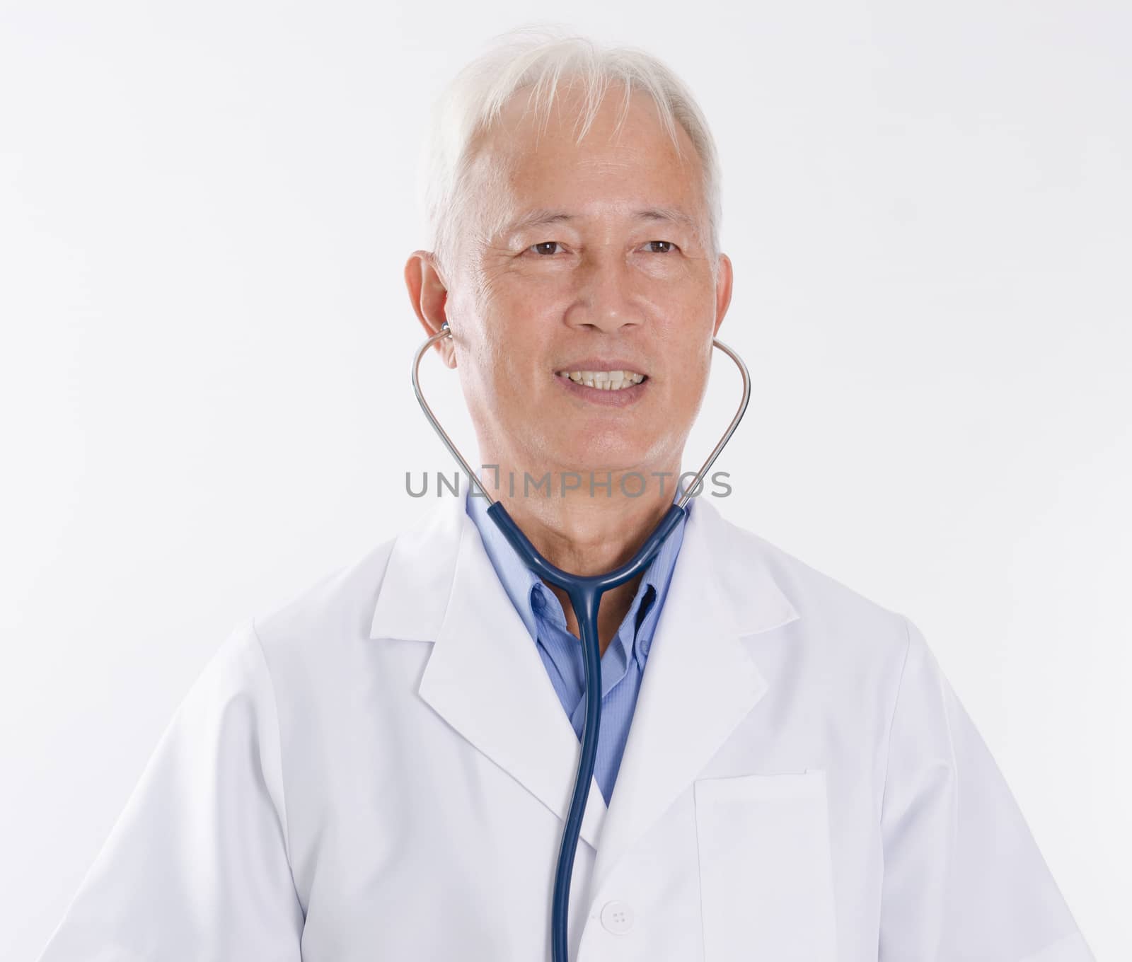 Portrait of Asian medical doctor smiling, standing isolated on white background.