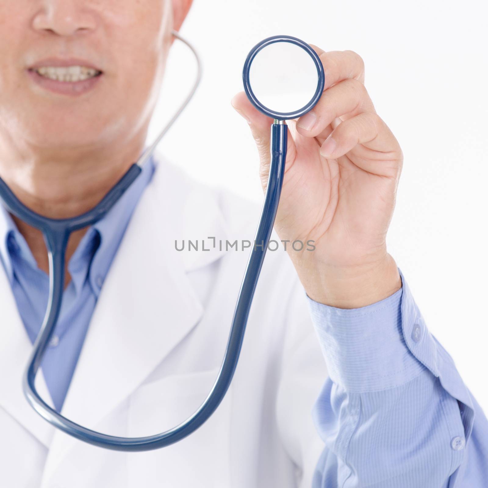 Portrait of medical doctor holding stethoscope, standing isolated on white background.