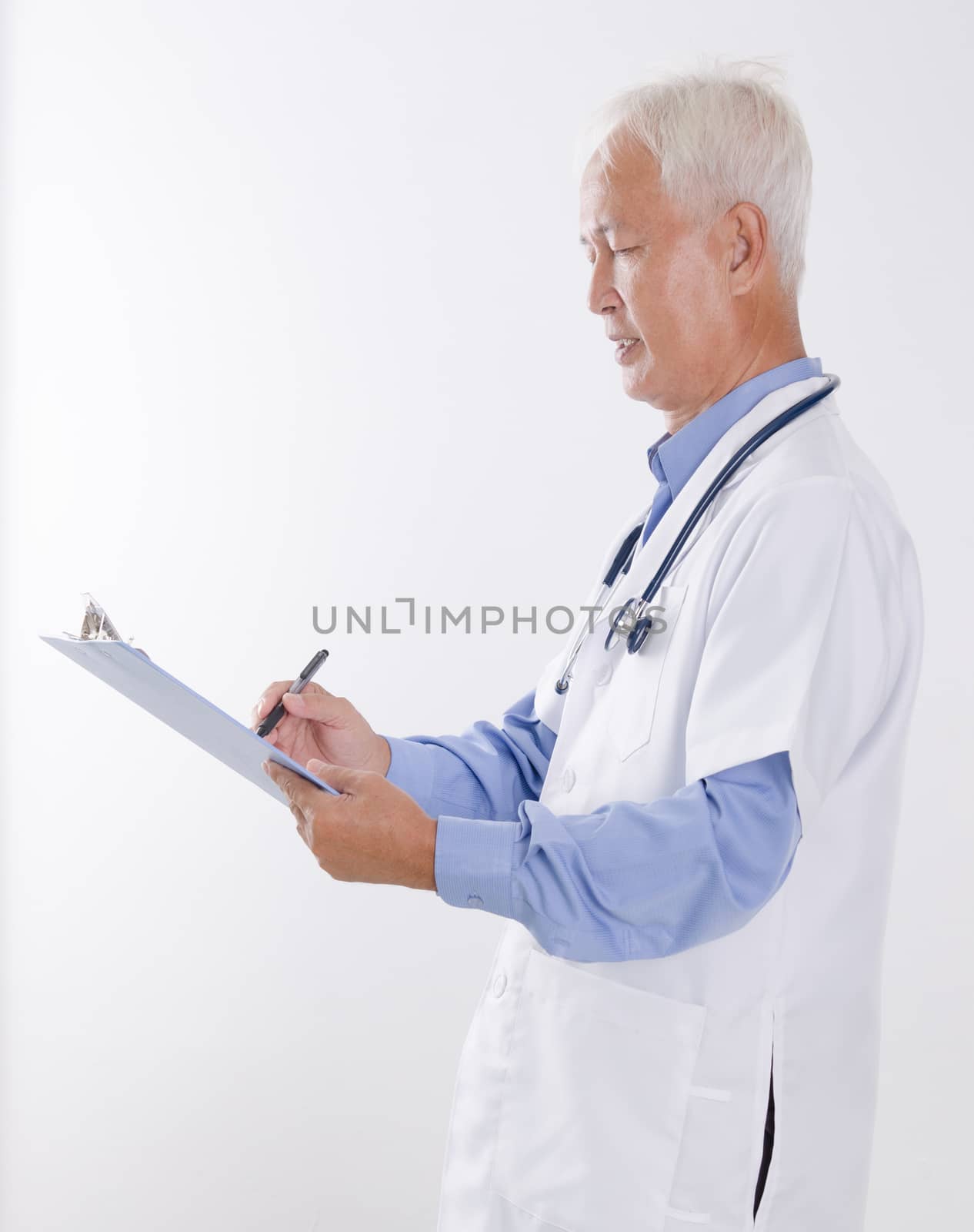 Senior Asian medical doctor writing report by szefei