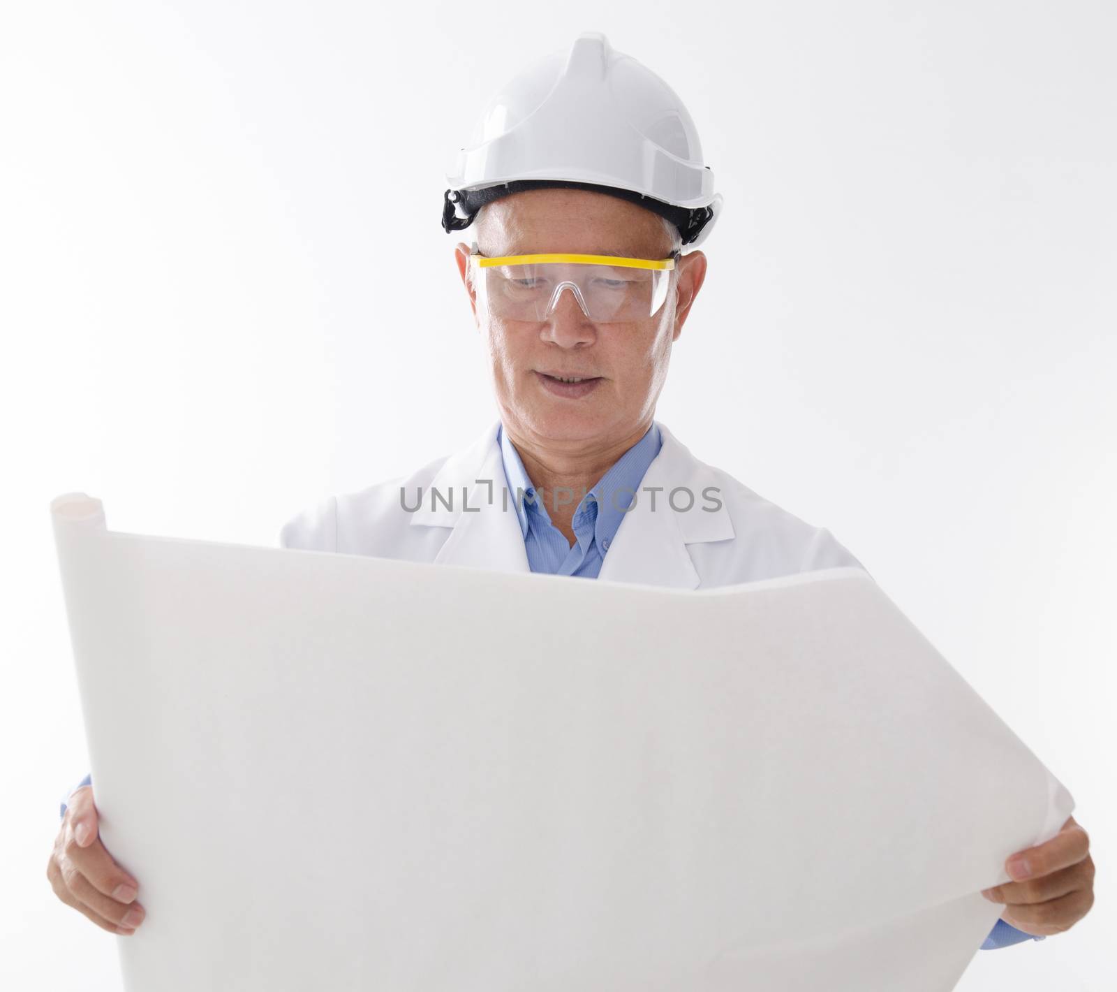 Portrait of Asian contractor with hard helmet reading on blueprint, standing isolated on white background.