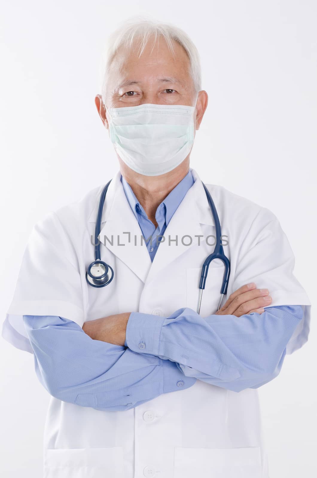 Portrait of Asian medical doctor in face mask arms crossed, standing isolated on white background.