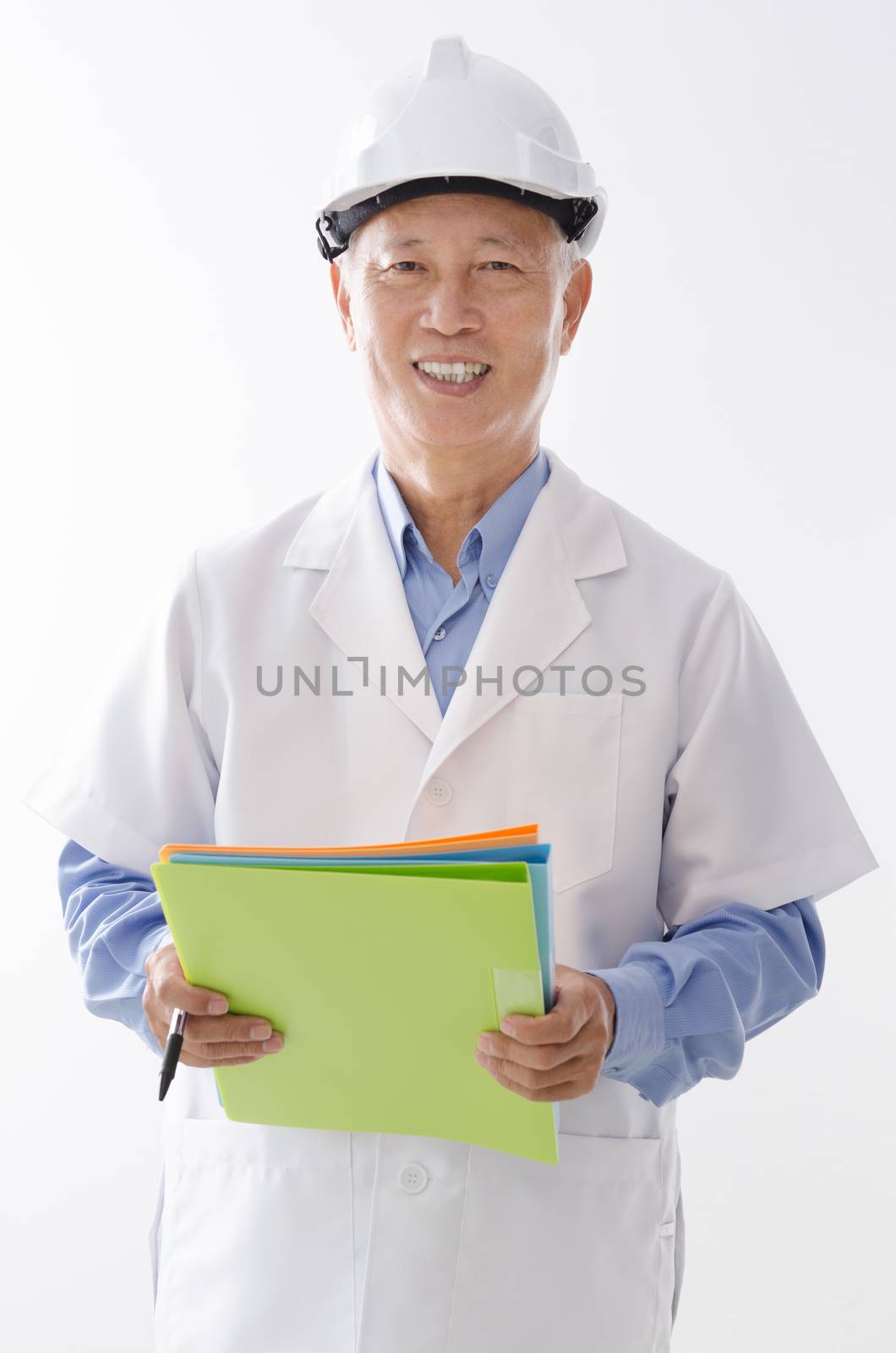 Portrait of old Asian engineer in uniform with hard hat, standing isolated on white background.