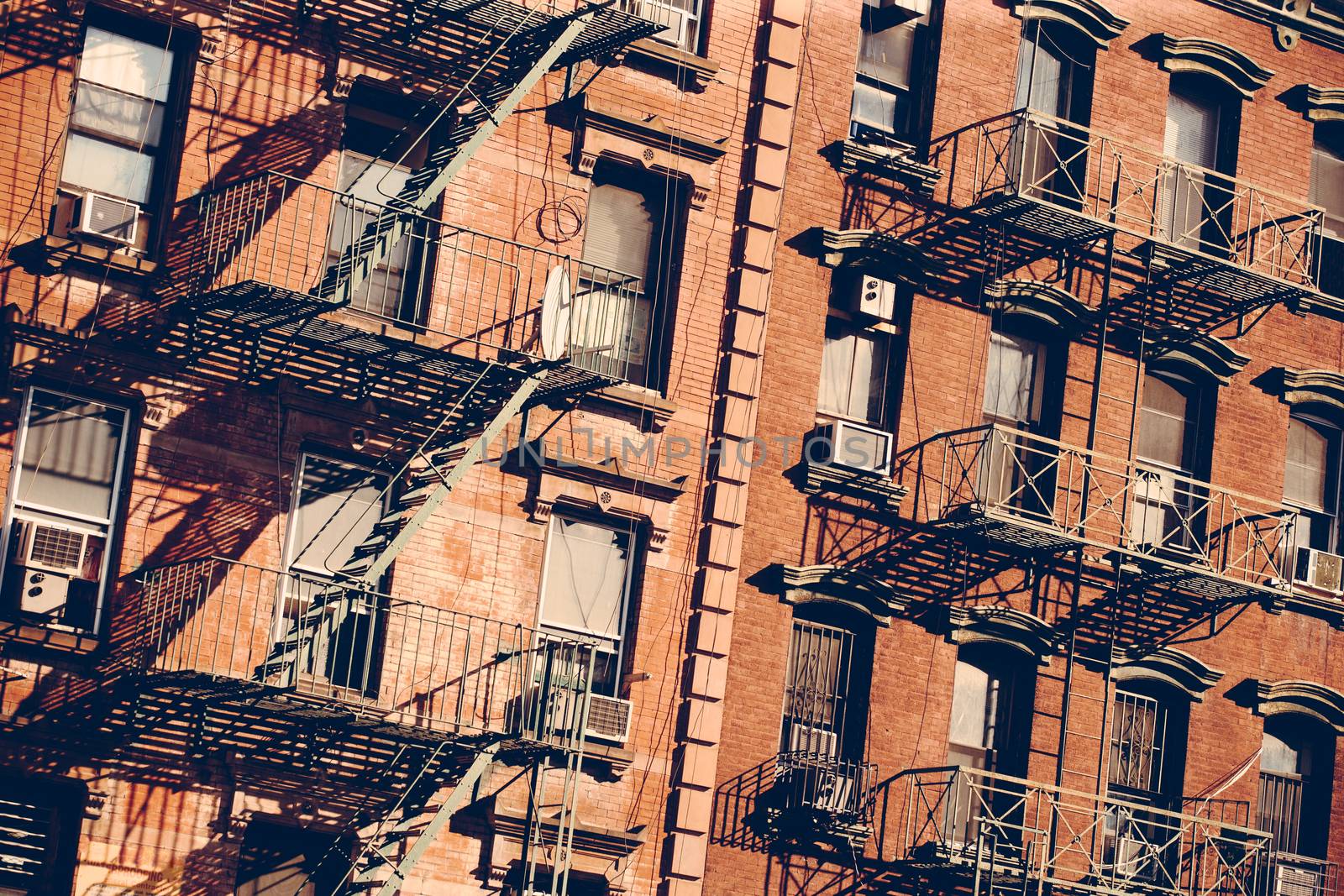 Photo of the exterior of a building in New York with old fire escape.
