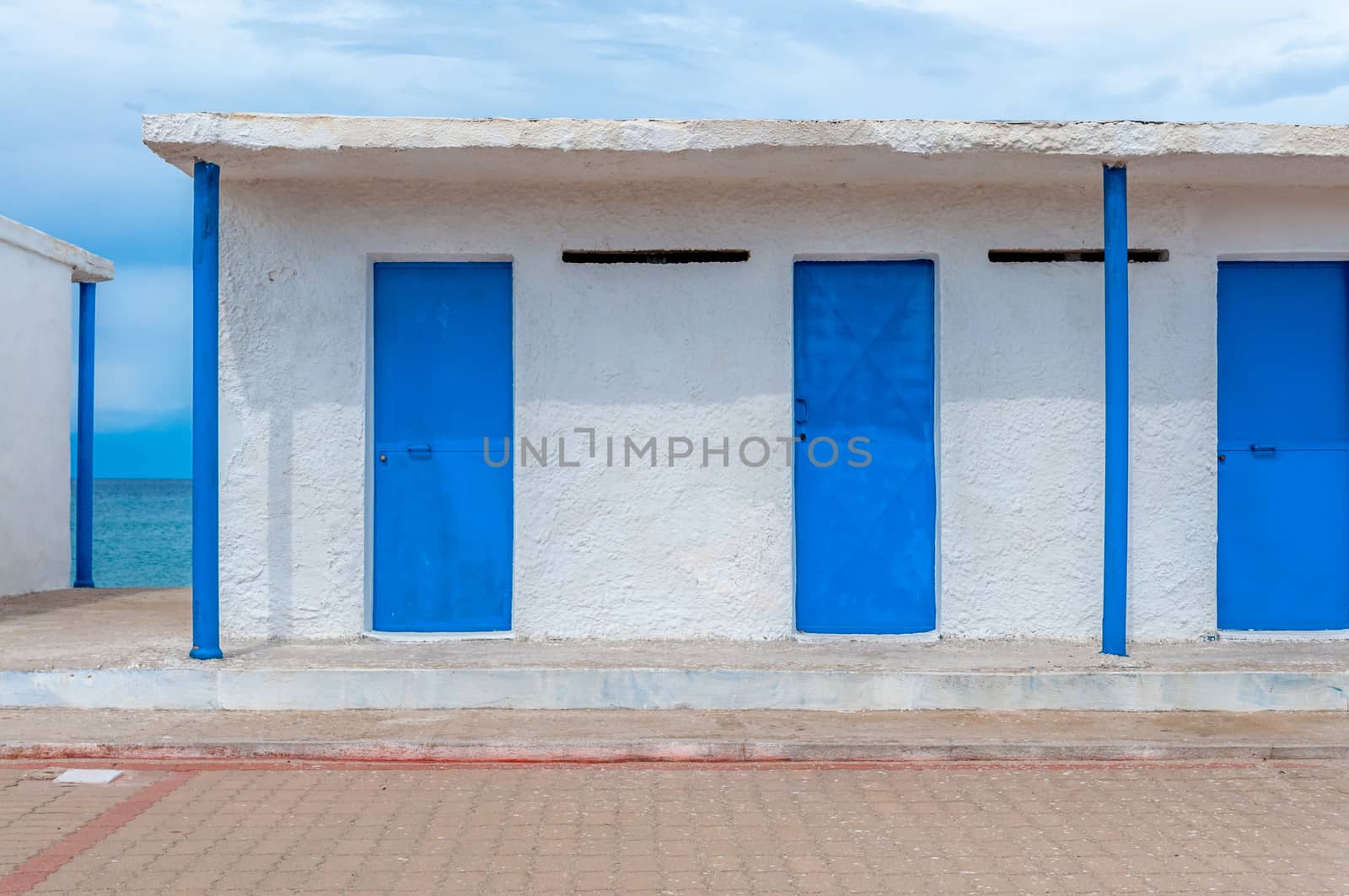 White and blue building on the beach in a cloudy day of autumn - Platamona - Sardinia - Italy