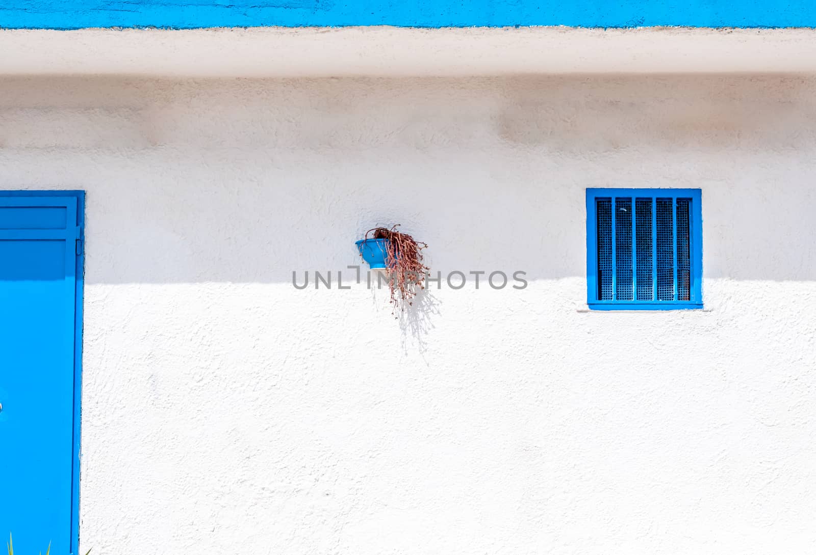 White and blue building on the beach by replica