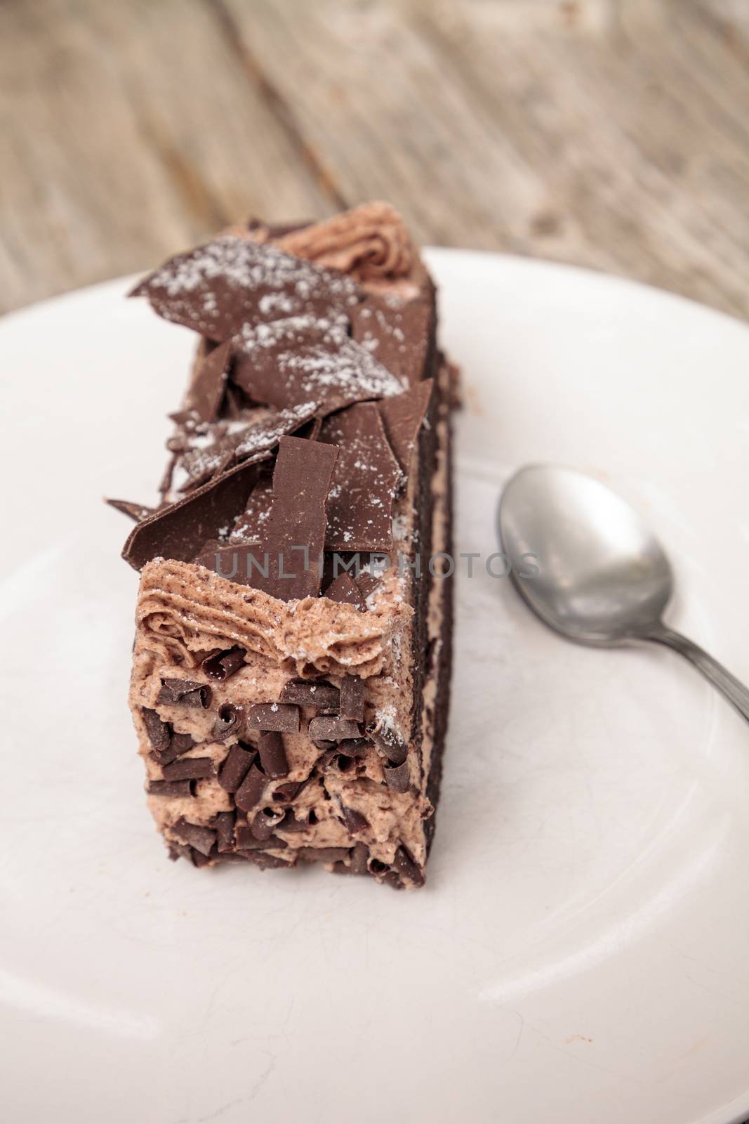 Moist devils food chocolate cake called Parisian cake with a chocolate mousse frosting and dark chocolate flakes.