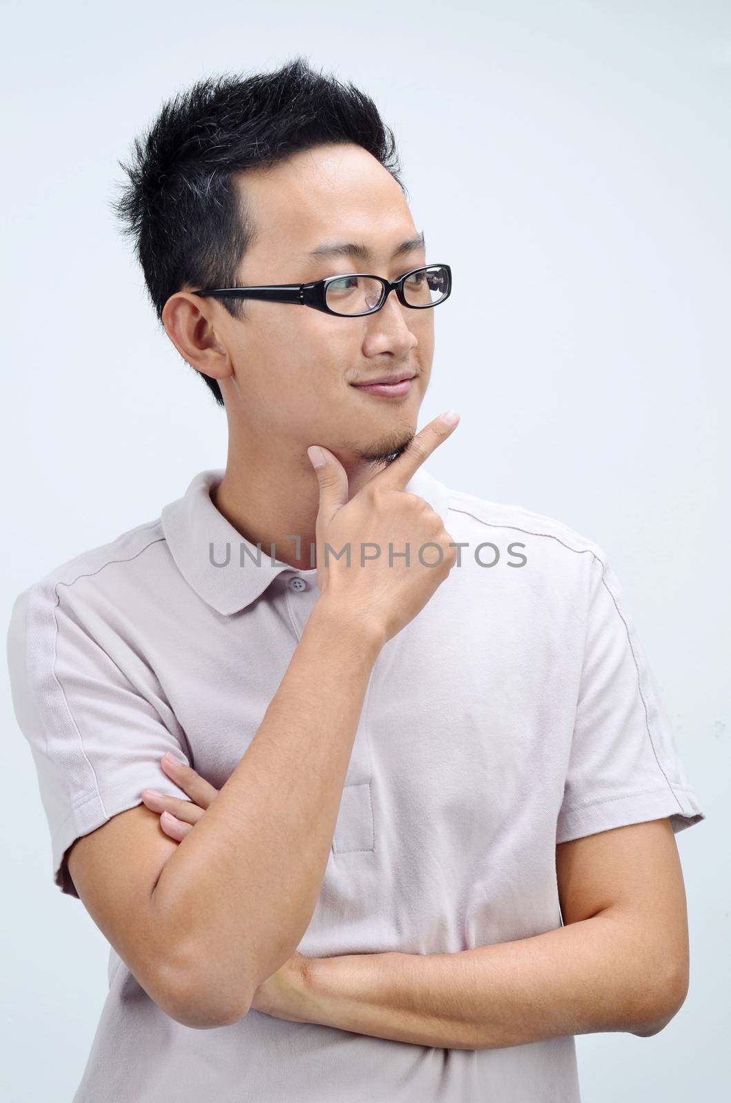 Portrait of happy Asian man arms crossed thinking and looking at side, standing isolated on plain background.