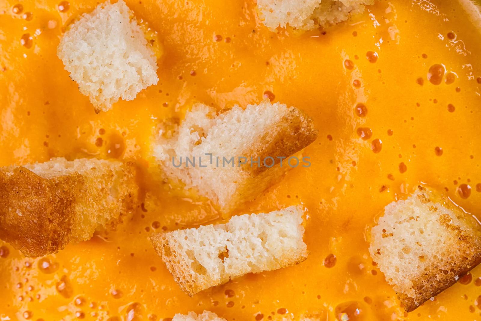 Texture of pumpkin soup with croutons close-up. Autumn dish