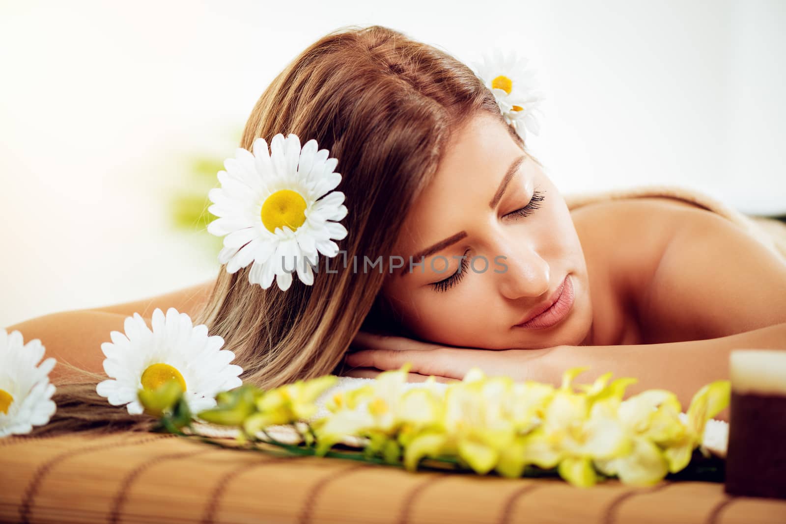 Beautiful young woman enjoying during a skincare treatment at a spa. She is relaxing with eyes closed. 