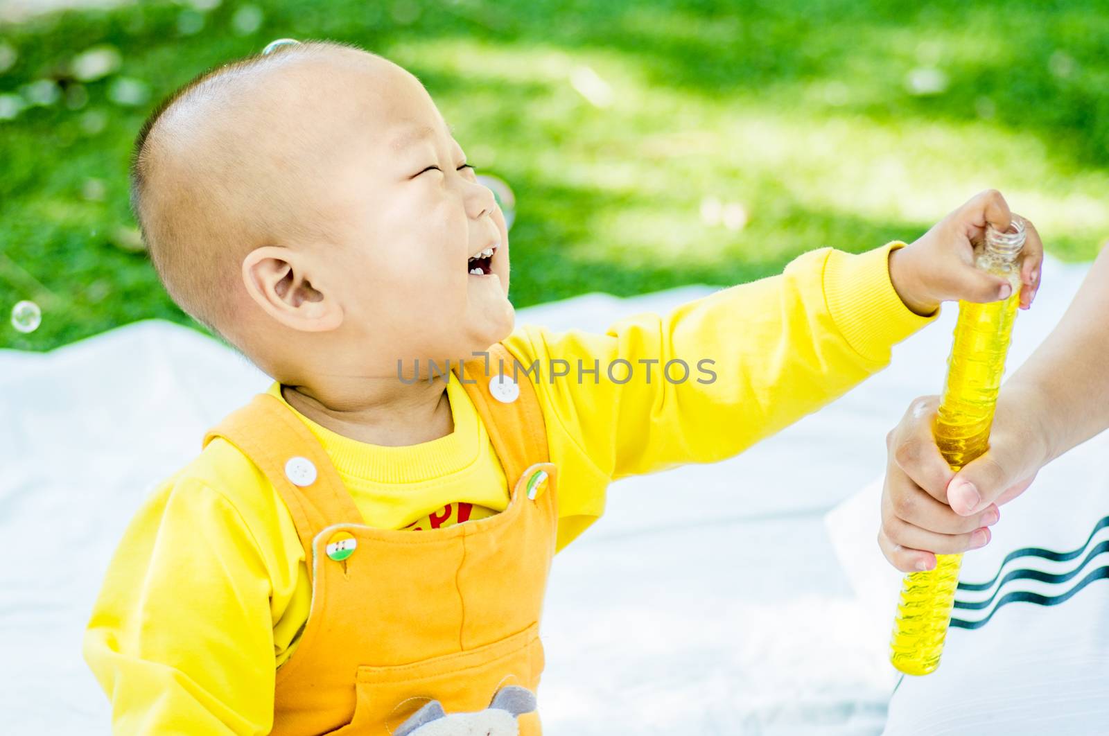 a baby plays on the mat in the park by Desperada