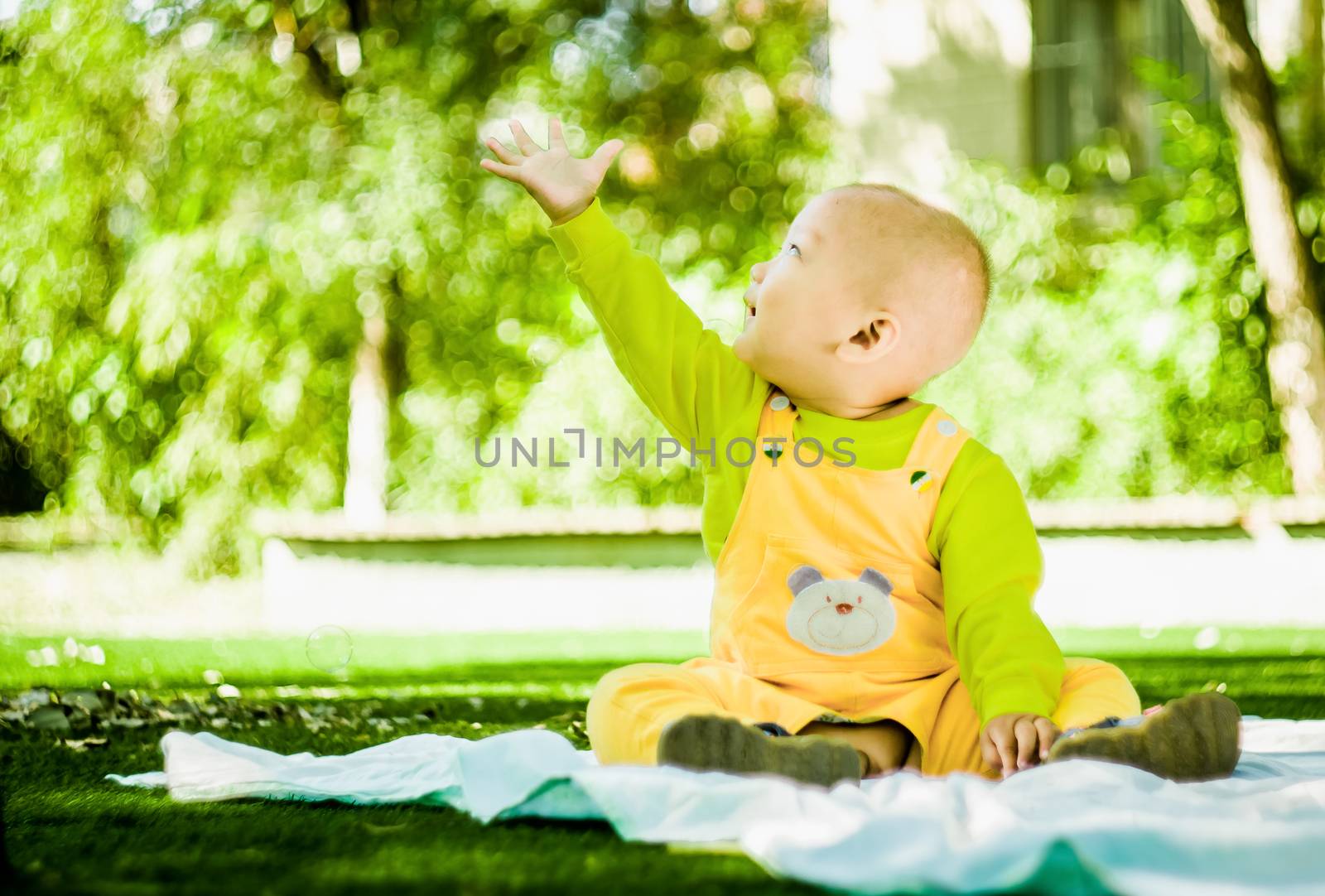 a baby plays on the mat in the park by Desperada