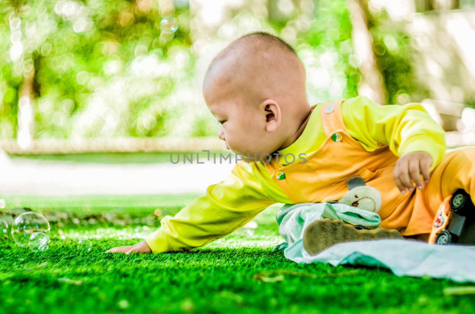 baby plays in the park with soap bubbles