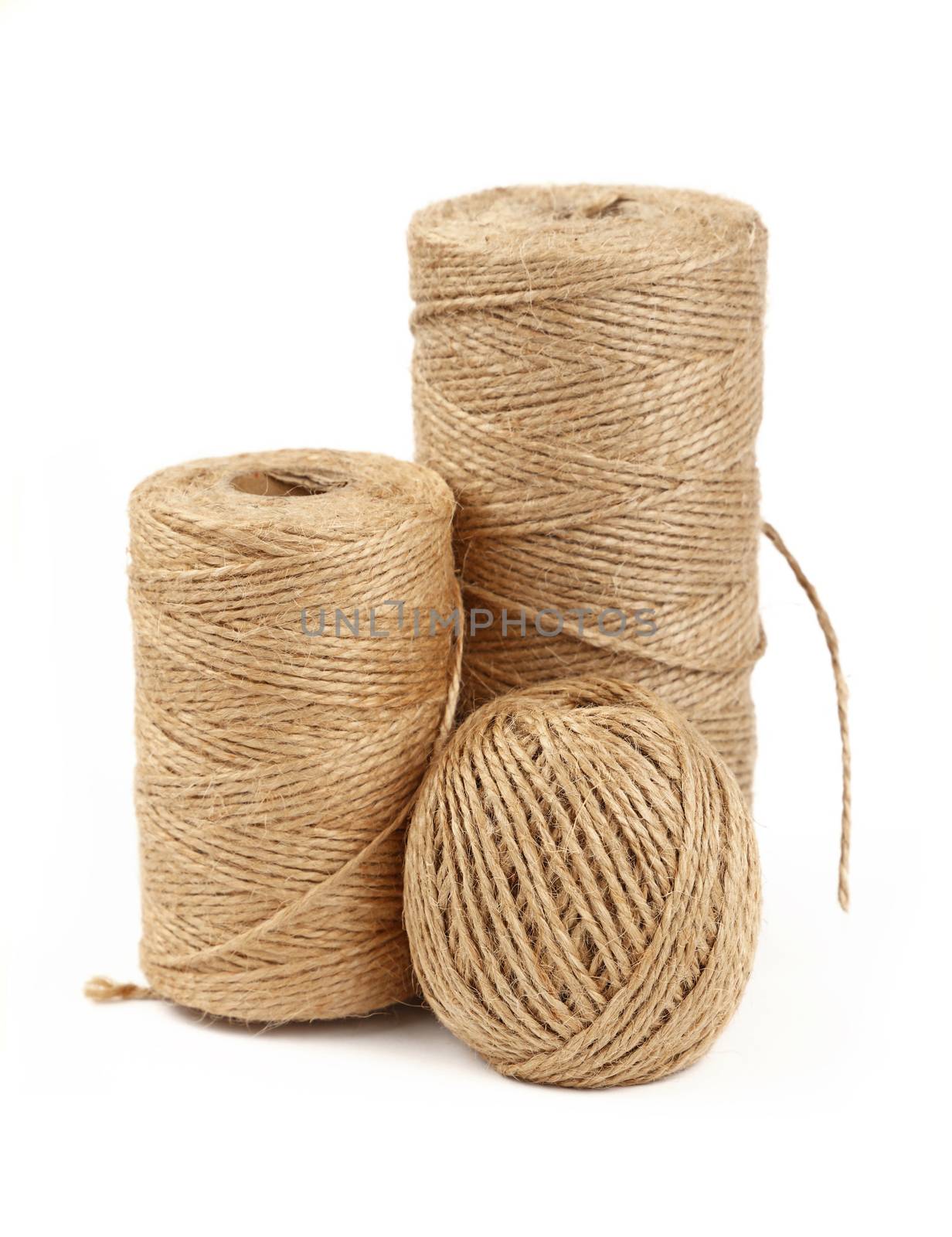 Group of three different coil bobbin of natural brown twine hessian burlap jute rope over white background, close up, high angle side view