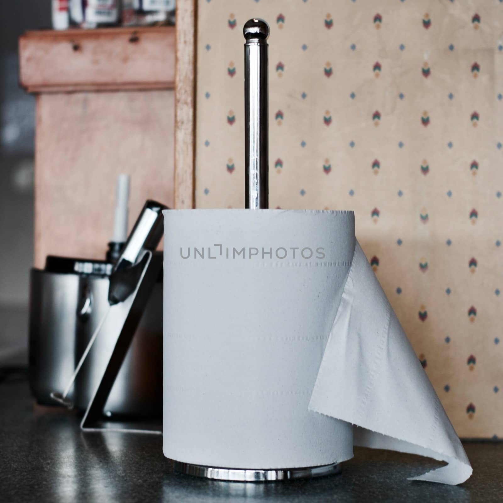 Big roll kitchen paper on the silver chrome holder near milk shaker.