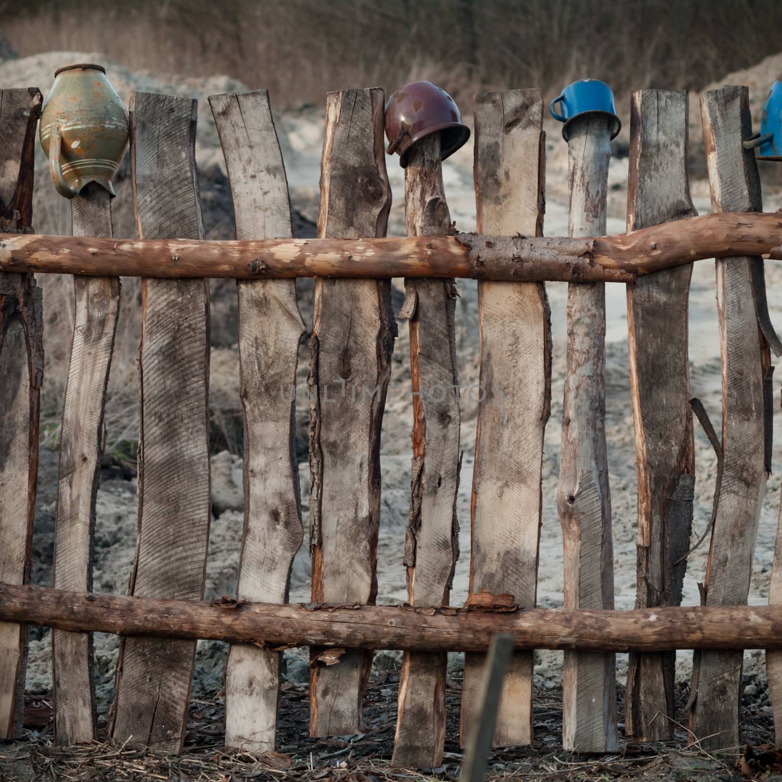 Old wooden boundary fence with nails on sunny day