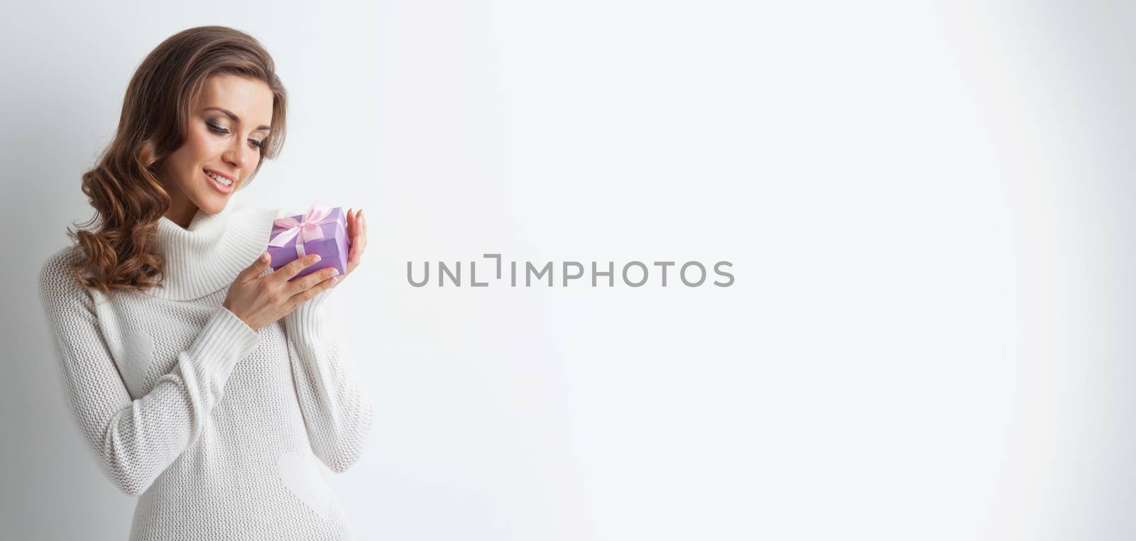 Young woman in white sweater with gift box