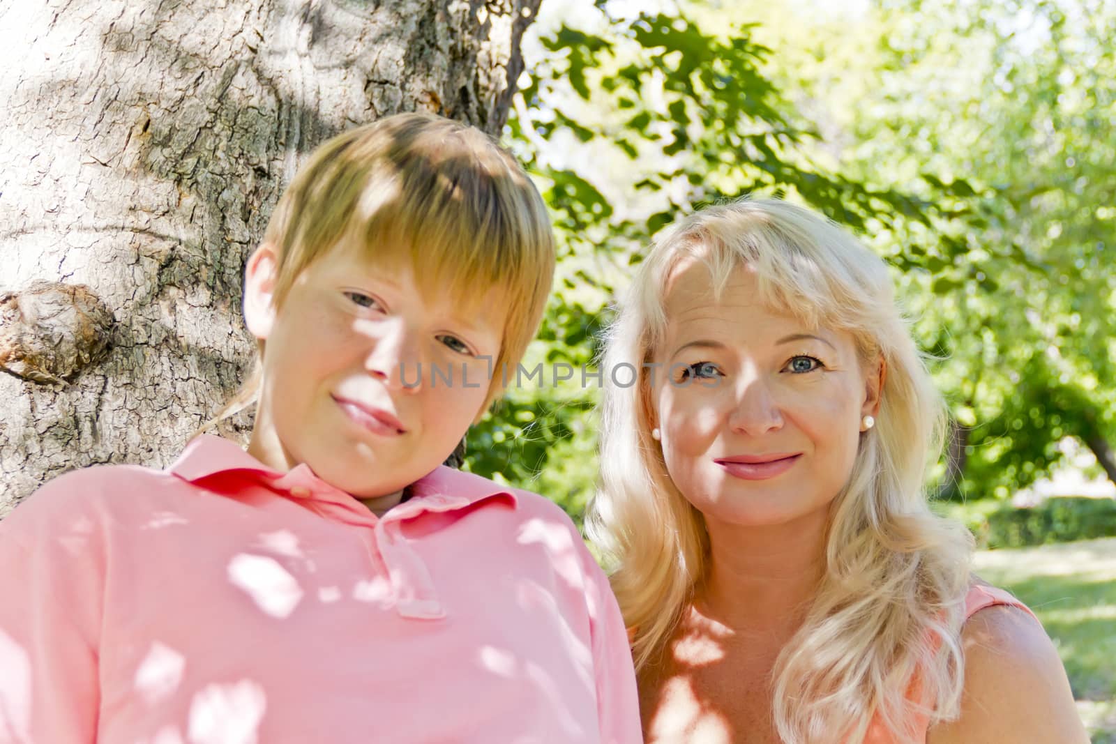 Blond woman and son smiling in the summer by Julialine