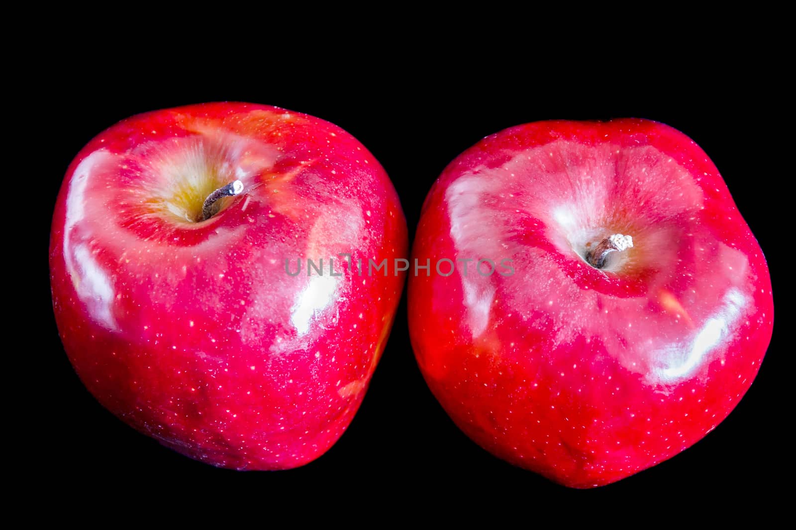 Two big red ripe appetizing apples on black background