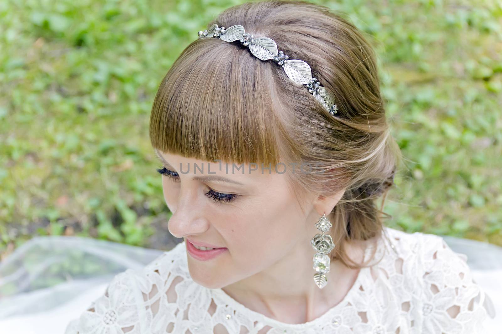 Portrait of beautiful smiling bride with diadem in the summer park