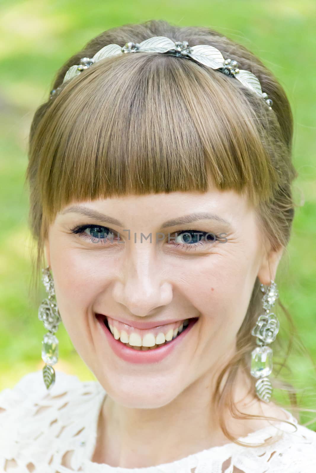 Portrait of smiling bride with diadem on green background