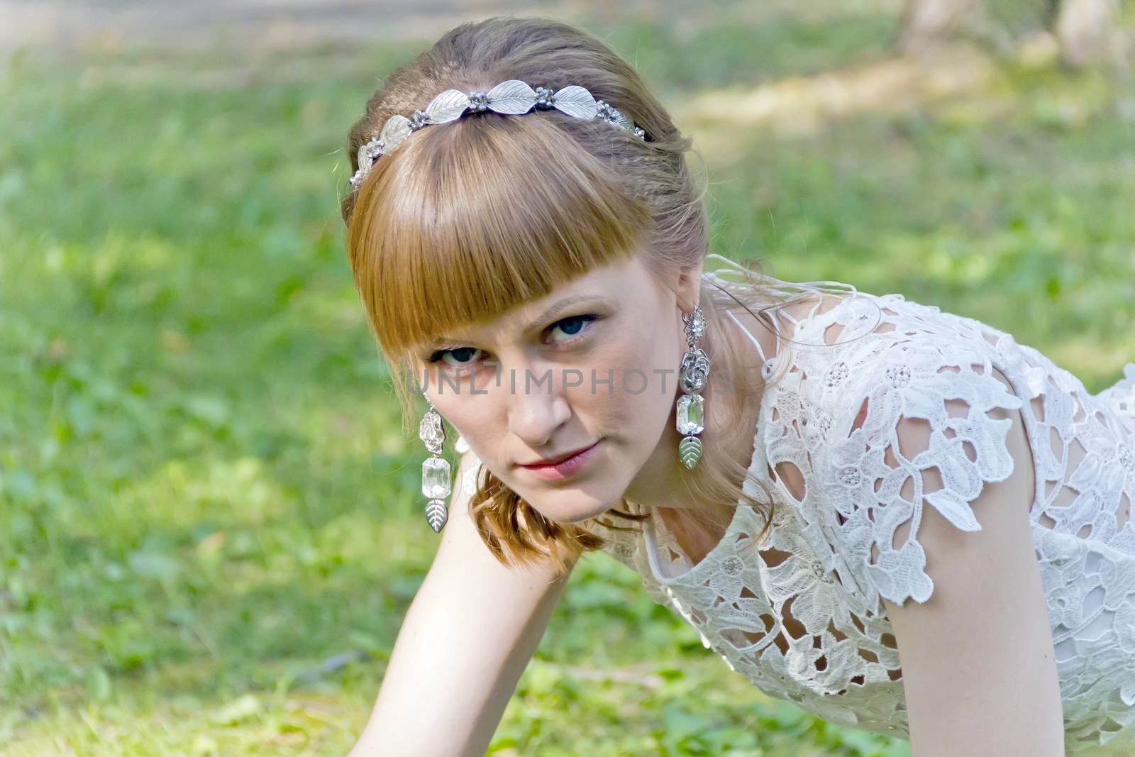 Beautiful portrait of serious bride with diadem in summer background