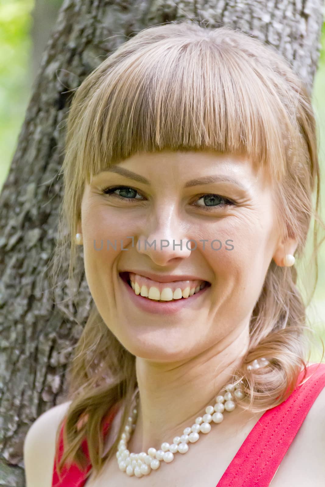 Portrait of smiling girl with white pearl on her neck