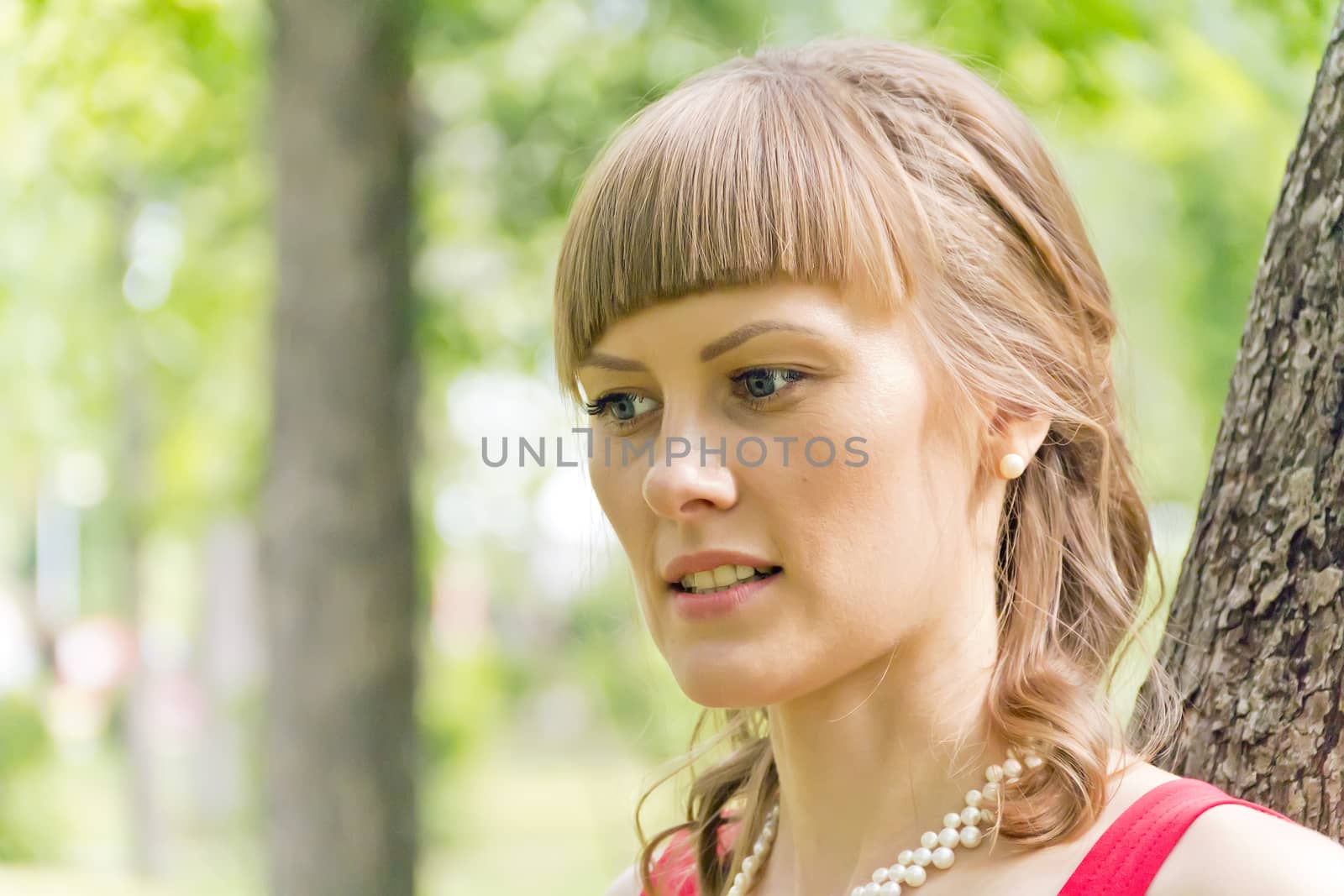 Portrait of beautiful girl with blue eyes on green background