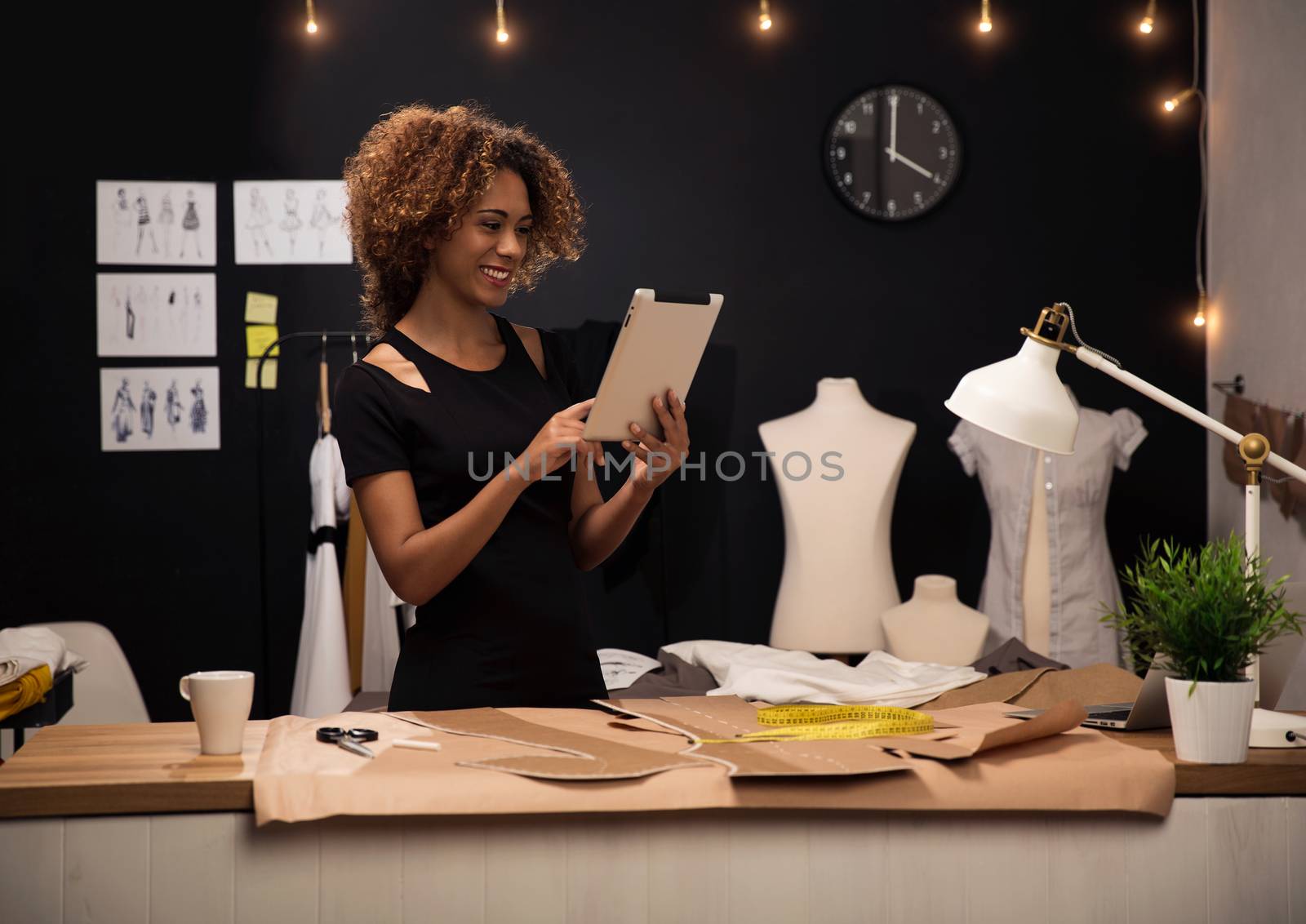 A young fashion designer on her atelier working with a tablet