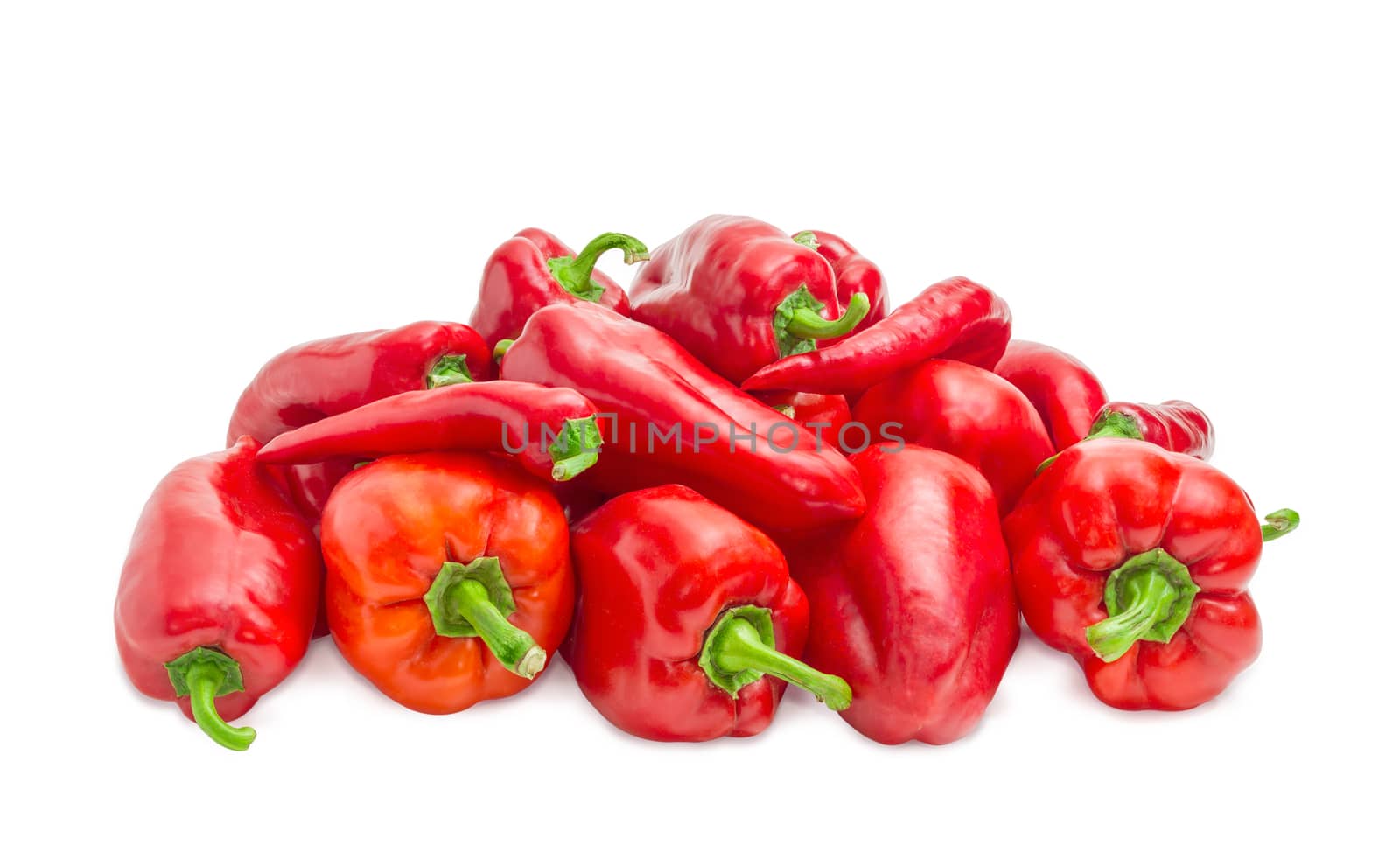 Pile of the freshly harvested different red bell peppers and red chili on a white background
