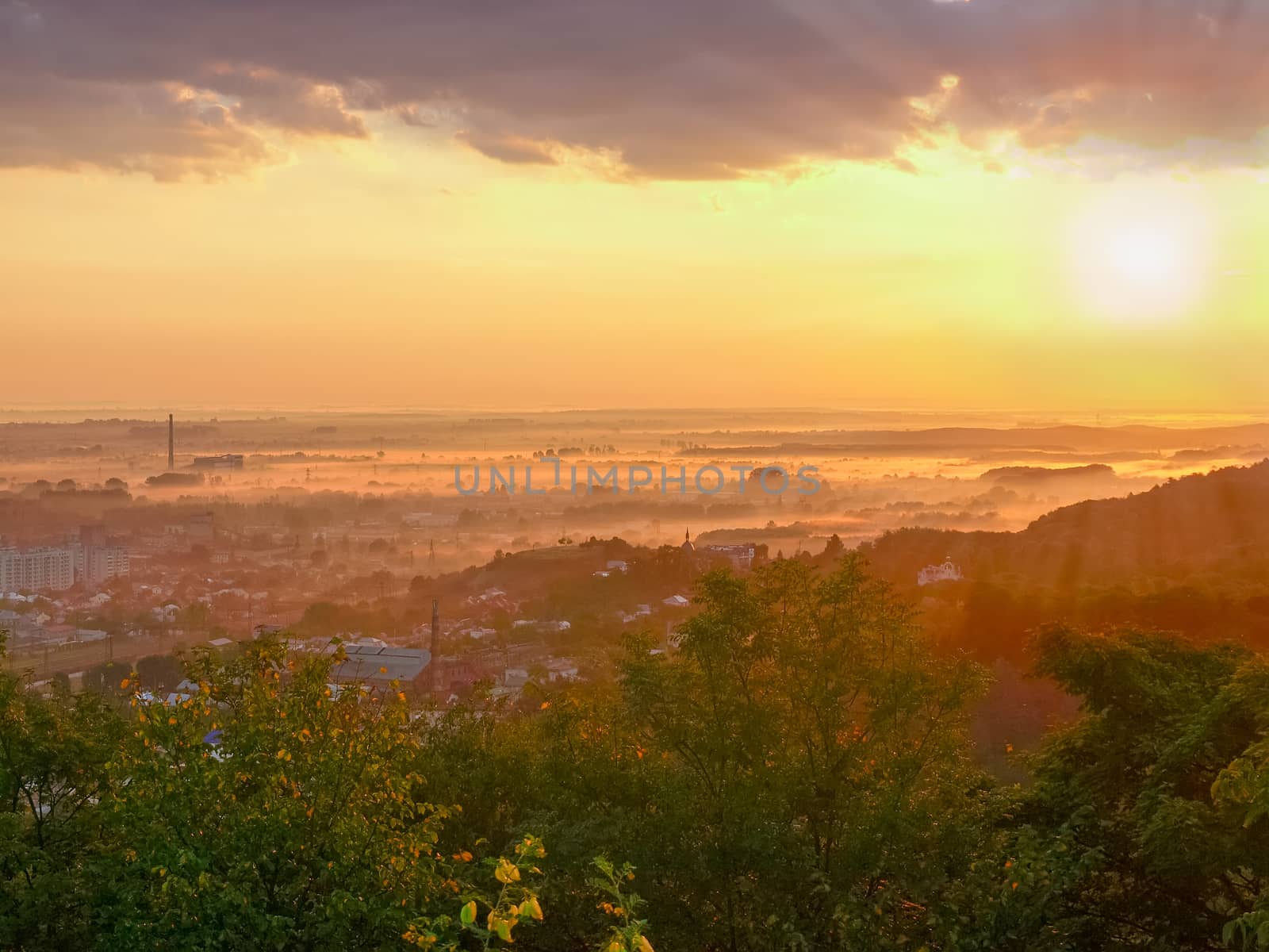 View of the outskirts of the city from hill during sunrise
