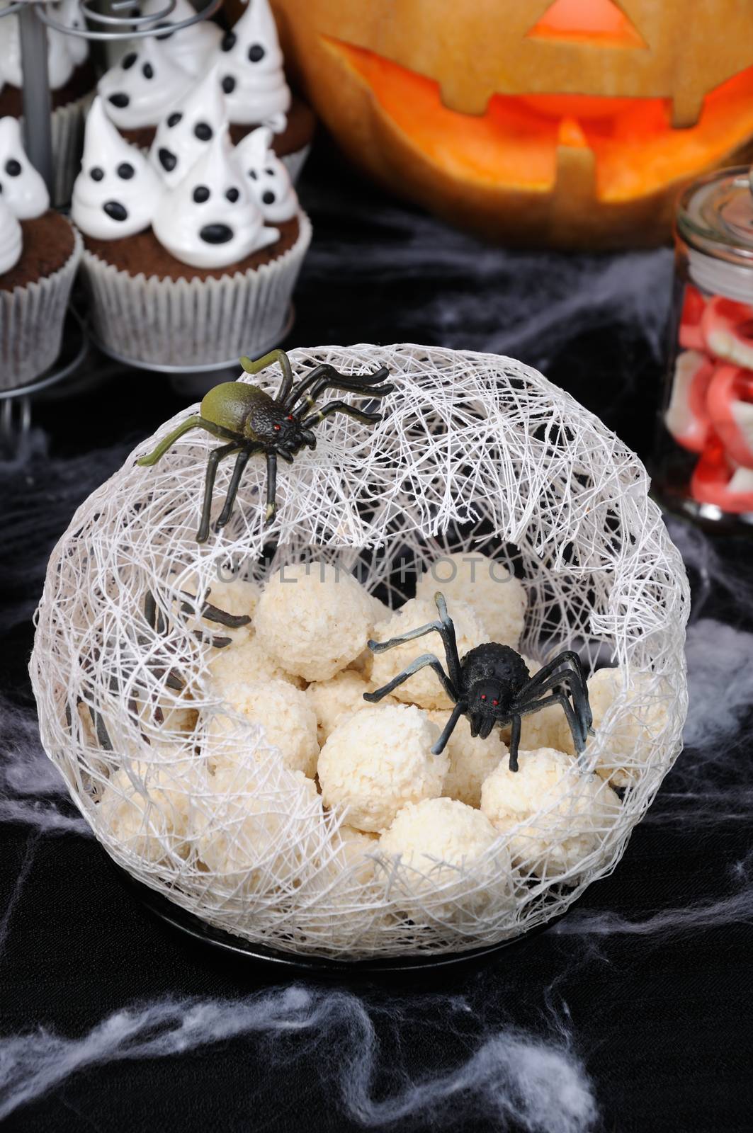 candy waffle balls in the form of spider eggs in a cocoon with a spider on the table for Halloween
