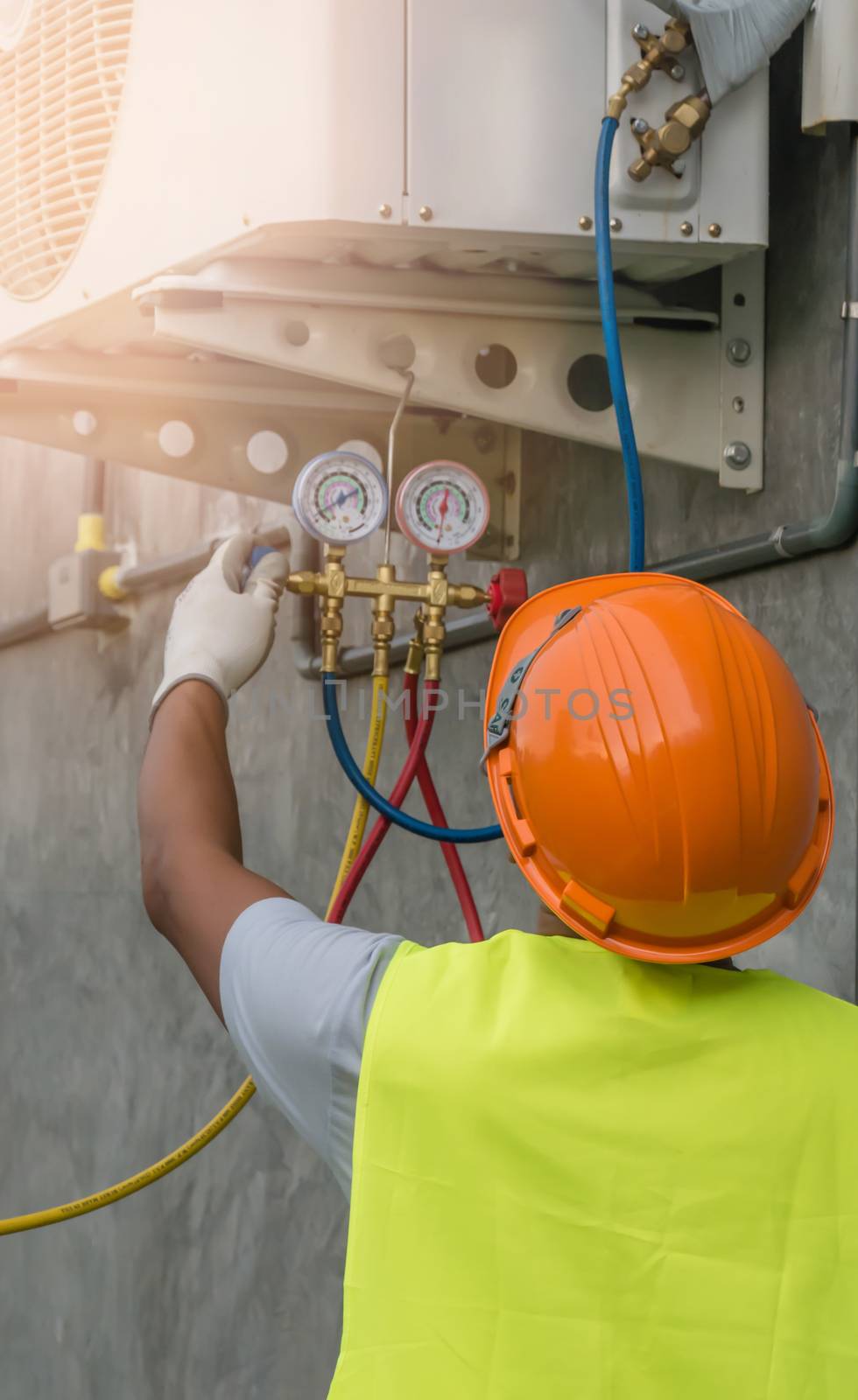 Auto mechanic uses a pressure gauge on the air compressor