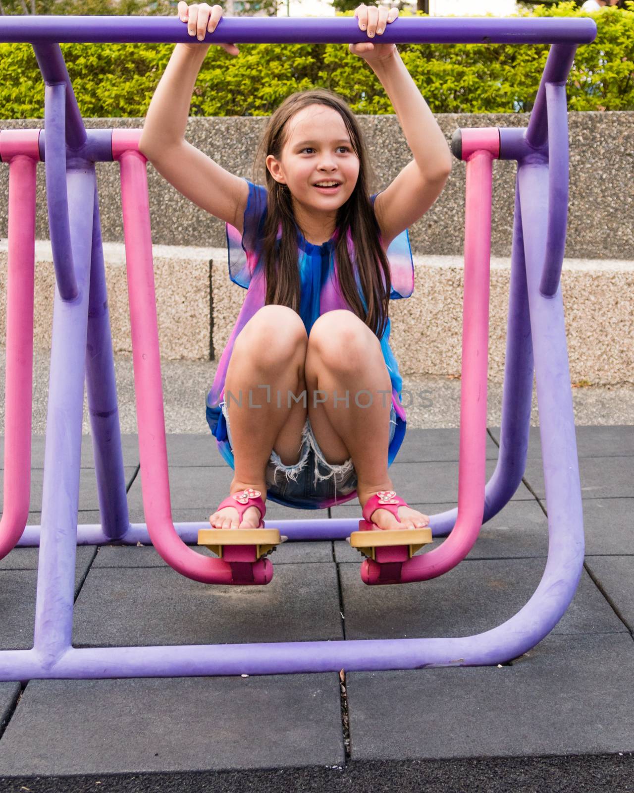 Young girl having fun on stepping fitness machine at park