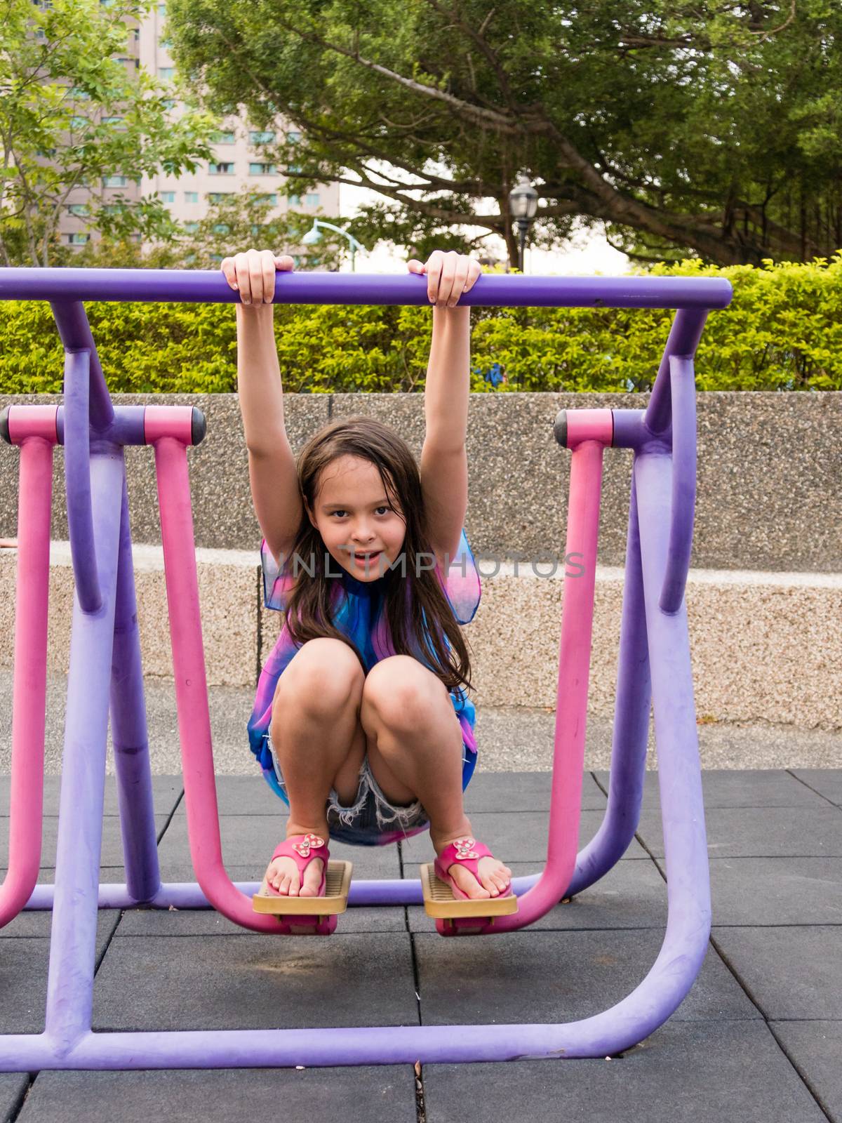 Young girl having fun on stepping fitness machine at park