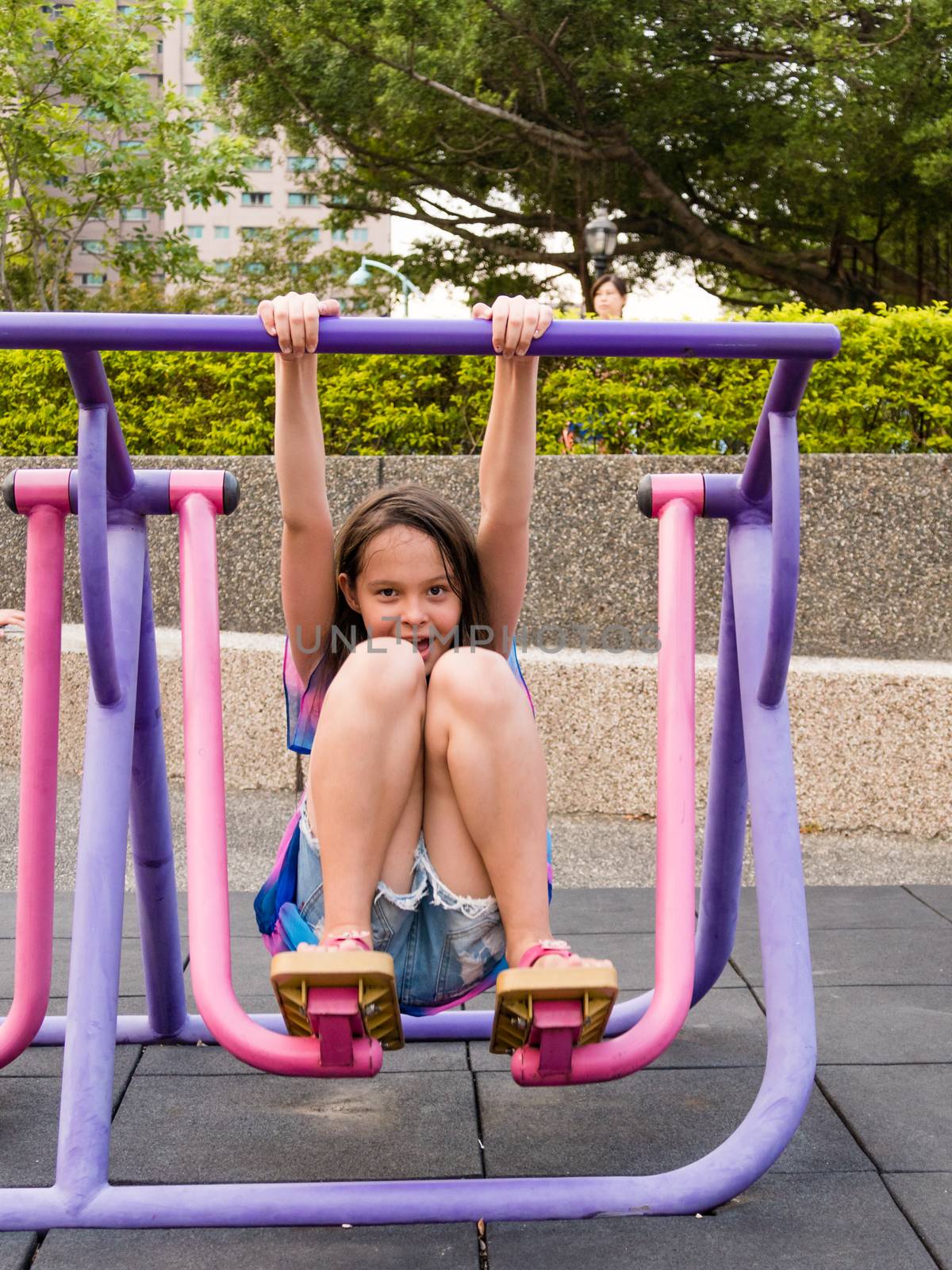 Young girl having fun on stepping fitness machine at park